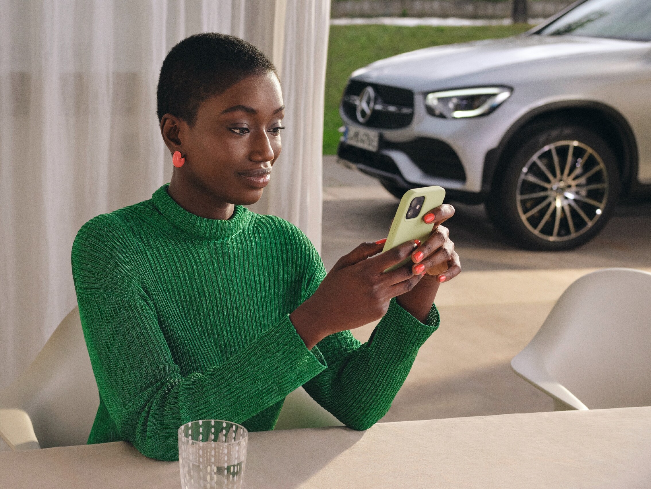 Une femme connecte le Mercedes me Adapter à son application sur le smartphone.