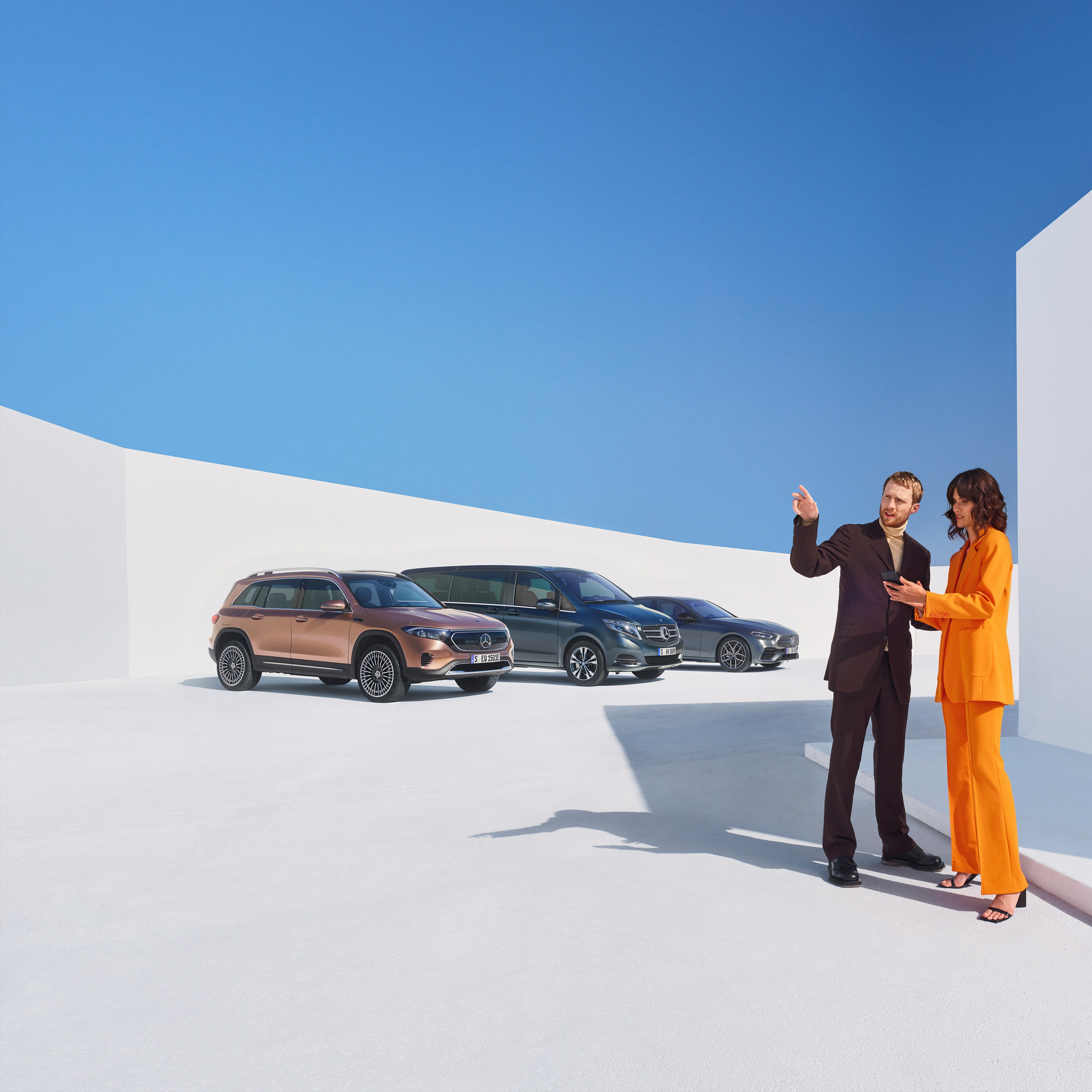 Zwei Frauen unterhalten sich über Digitale Extras für Geschäftskunden. Im Hintergrund sind drei Mercedes-Benz Fahrzeuge zu sehen.