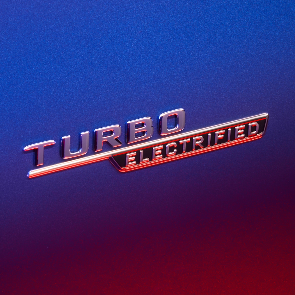 Badge TURBO E PERFORMANCE sur l'aile avant éclairé en rouge.