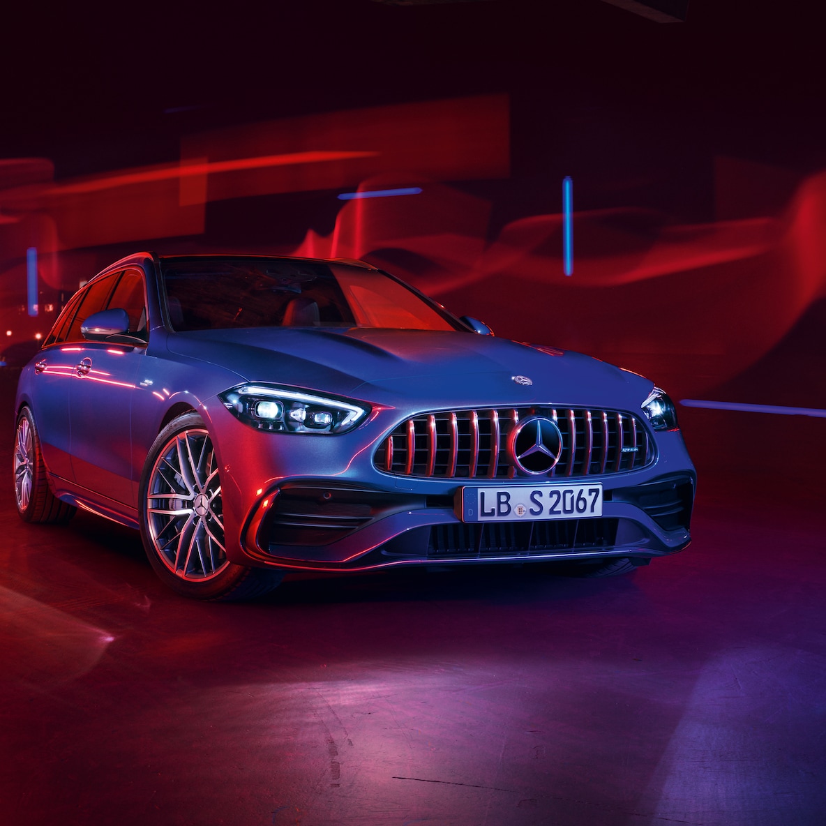 Une Mercedes-AMG C 43 en vue avant sur fond rouge.