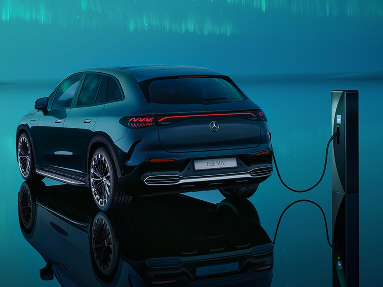 Le nouvel Mercedes EQE SUV branché sur une borne de recharge se trouvant sur un parking d'entreprise.