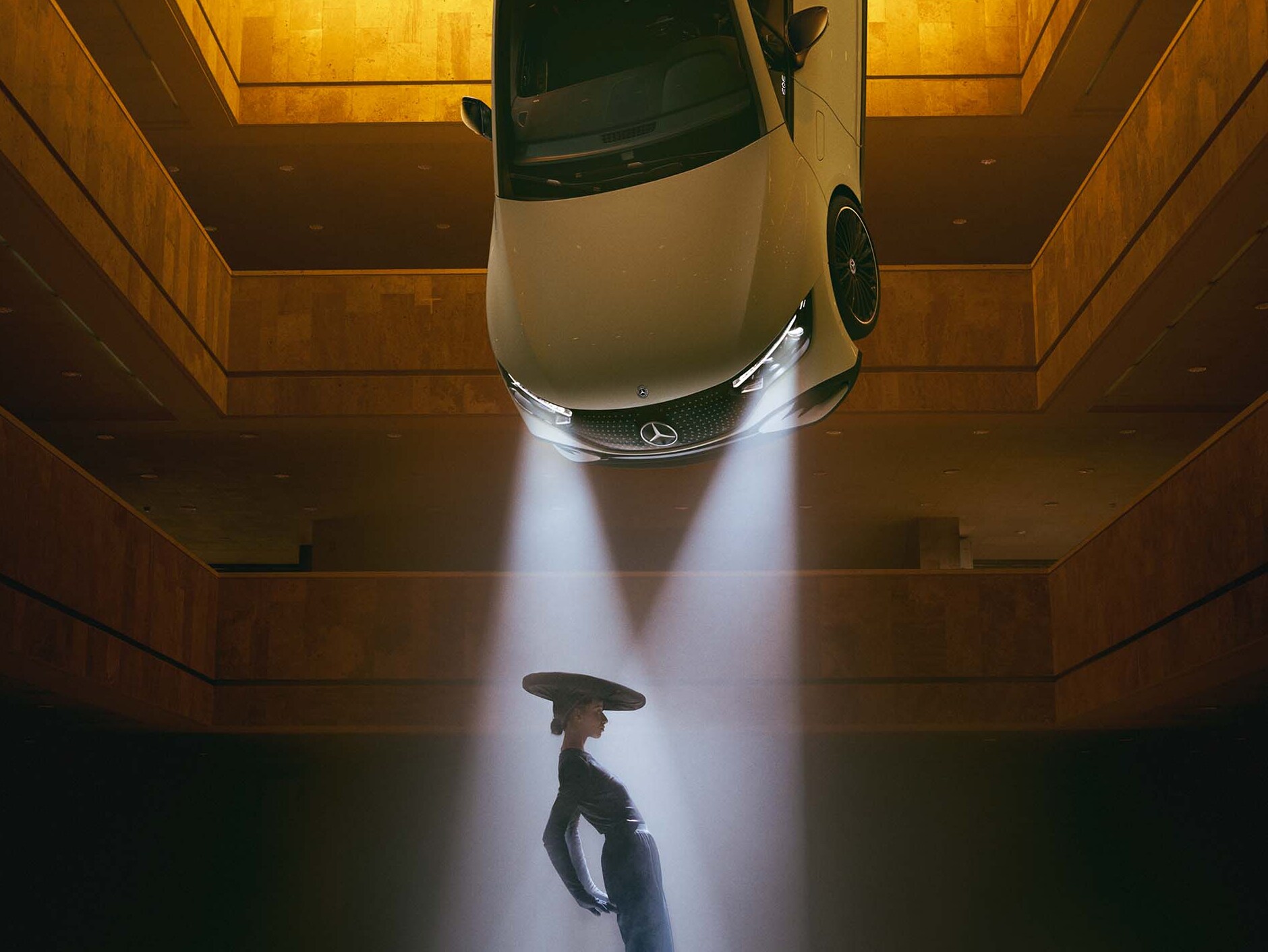 Ein dunkler Raum, an dessen Decke Scheinwerfer hängen, in deren Lichtkegel eine Frau steht.