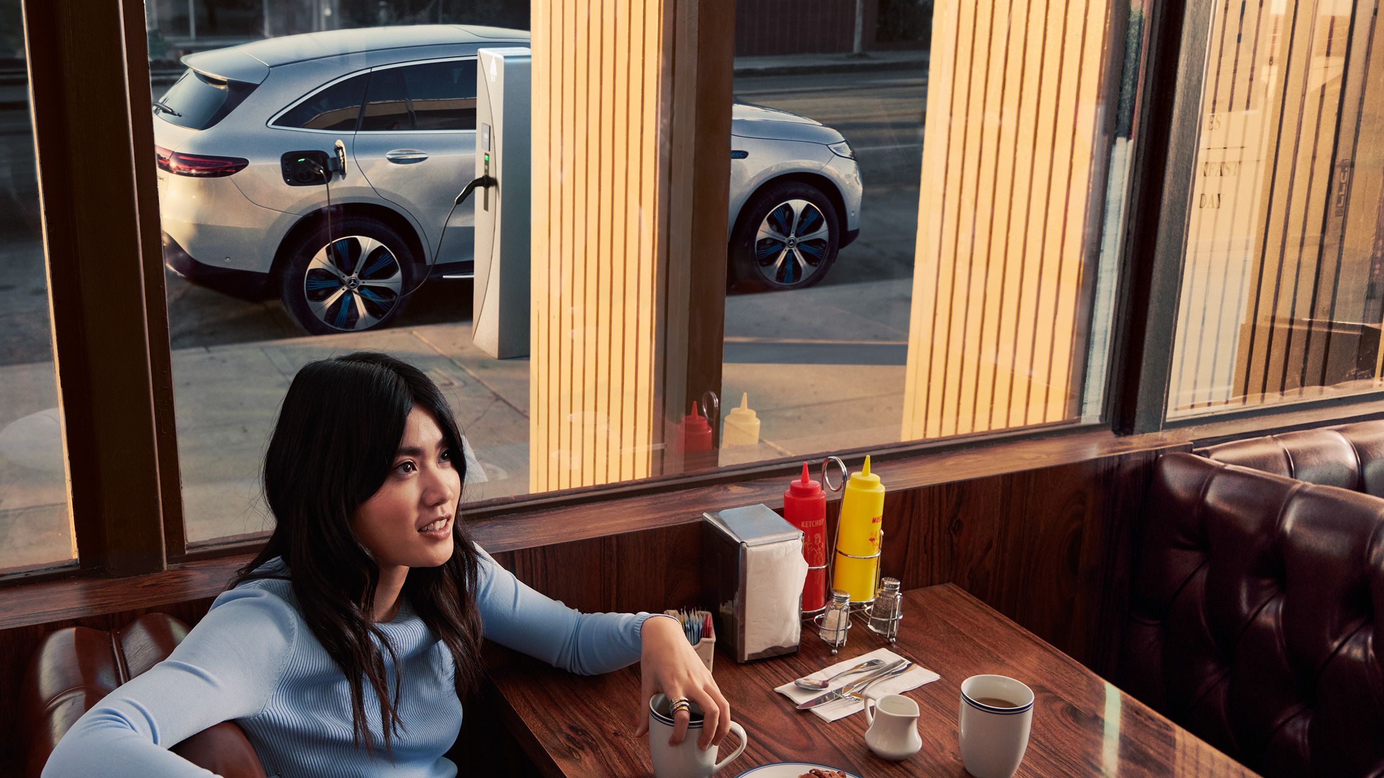 Mercedes-Benz Public Charging Person wartet im Restaurant während einMercedes-Benz läd