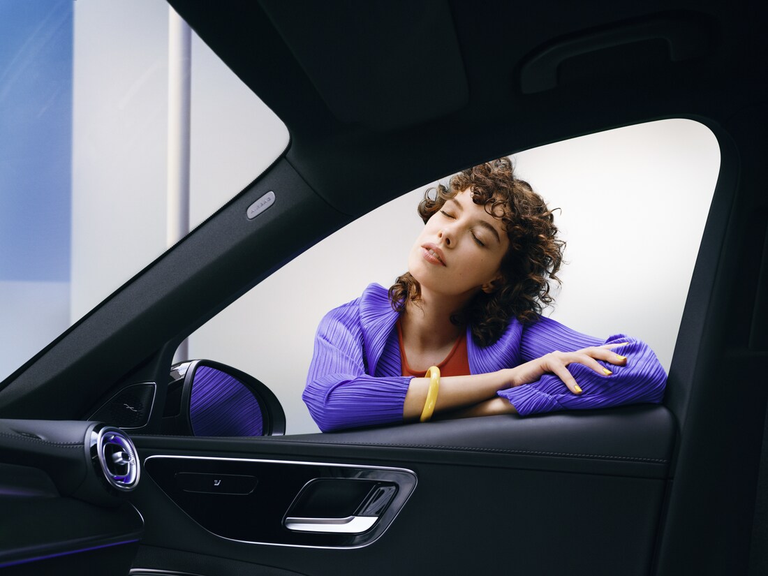 Eine Frau genießt ihren sauberen Mercedes-Benz.