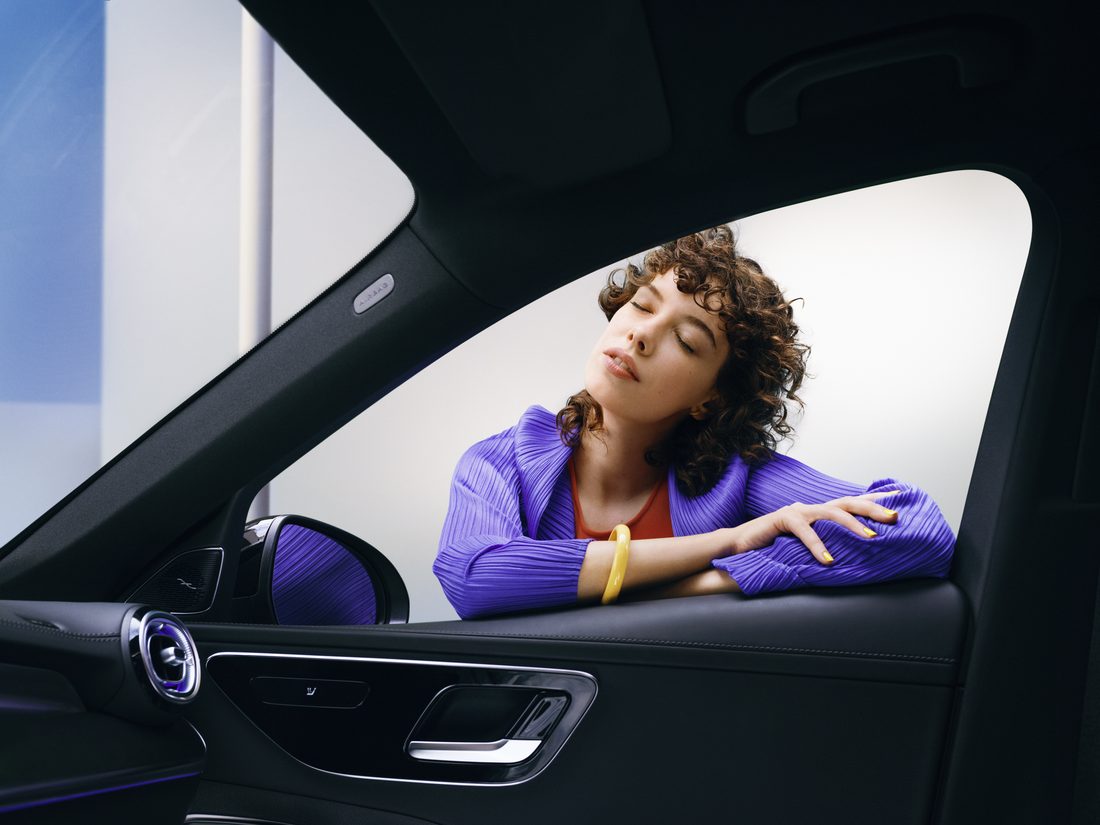 Mercedes-Benz | Original-Pflegeprodukte Eine Frau genießt ihren sauberen Mercedes-Benz.