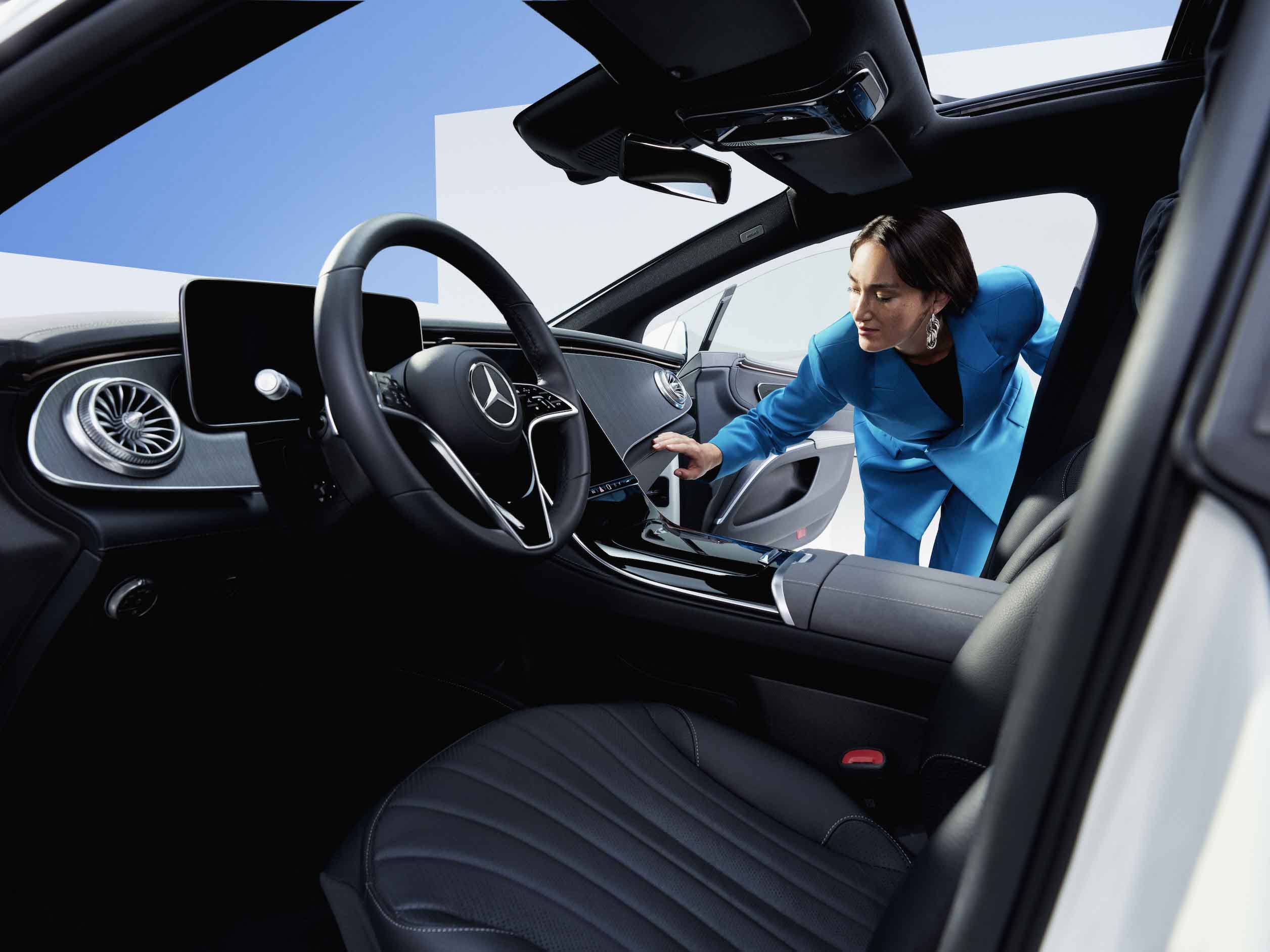 Mercedes-Benz | Original-Pflegeprodukte Eine Frau begutachtet den sauberen Innenraum eines Mercedes-Benz.