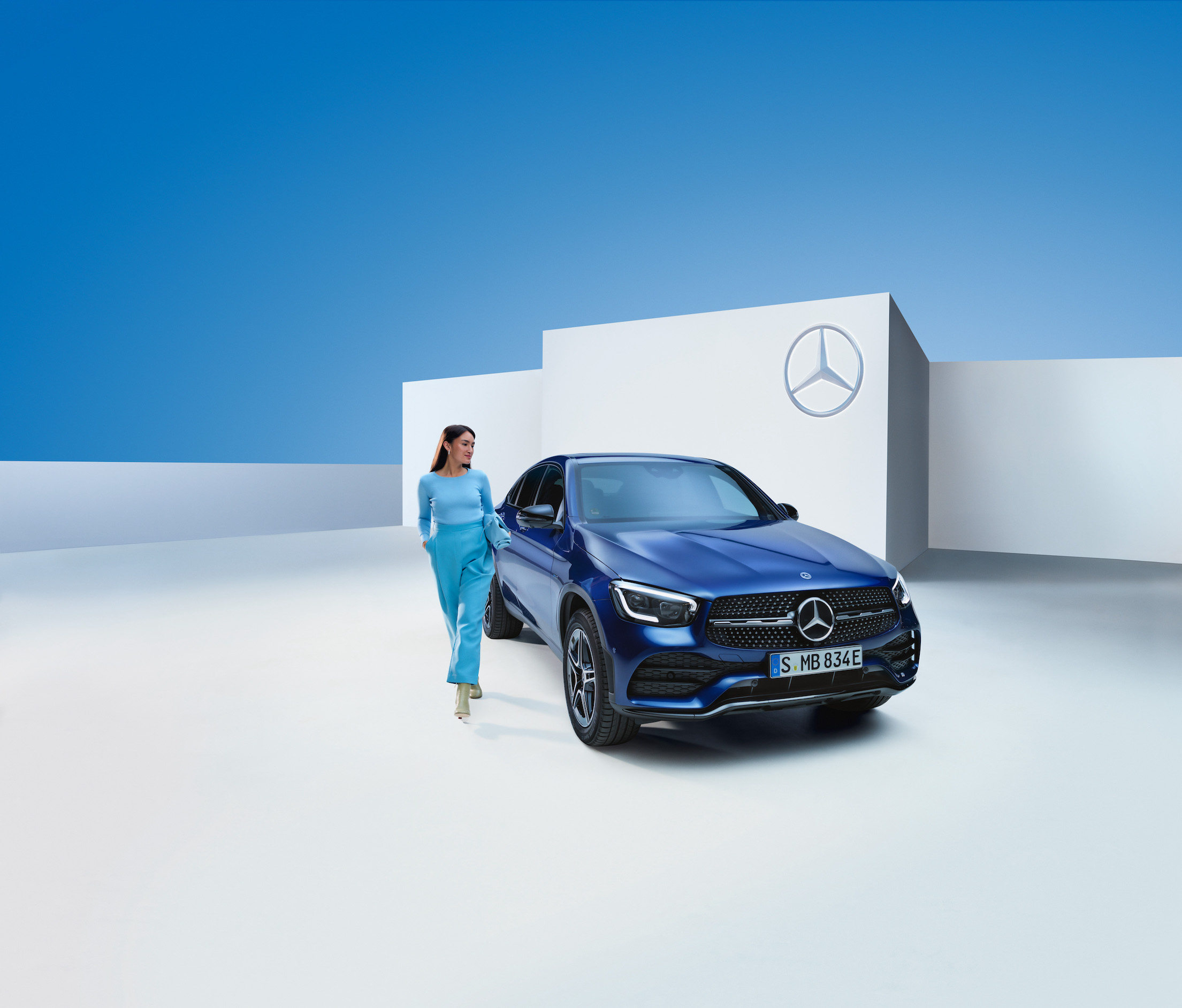 Mercedes-Benz | Original-Pflegeprodukte Eine Frau steht neben ihrem Mercedes-Benz.