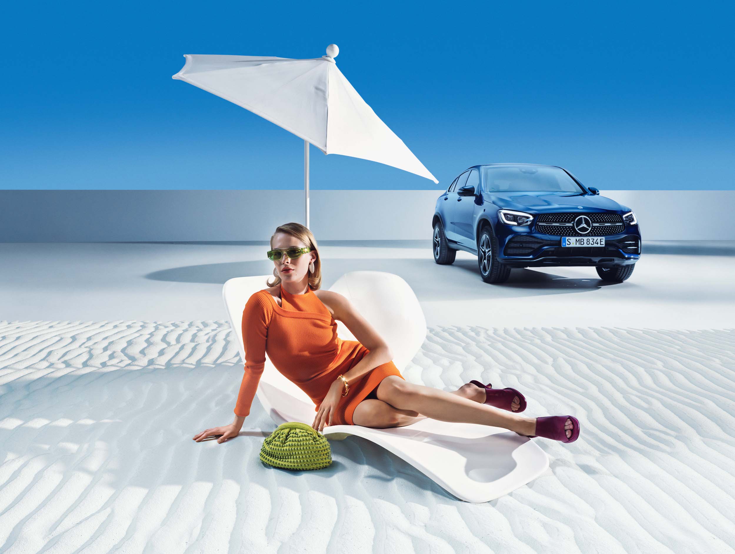 Mercedes-Benz | Original-Pflegeprodukte Eine Frau entspannt am Strand vor ihrem Mercedes-Benz.