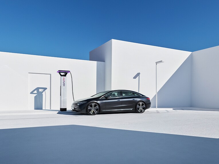Une Mercedes-EQ EQS à côté d’une borne de recharge.