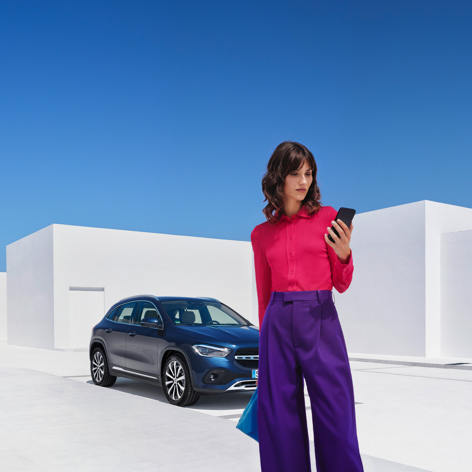 So funktioniert's | Apps | Mercedes-Benz Eine Frau stellt per Mercedes-Benz App auf ihrem Smartphone eine Verbindung mit ihrem Mercedes-Benz her.