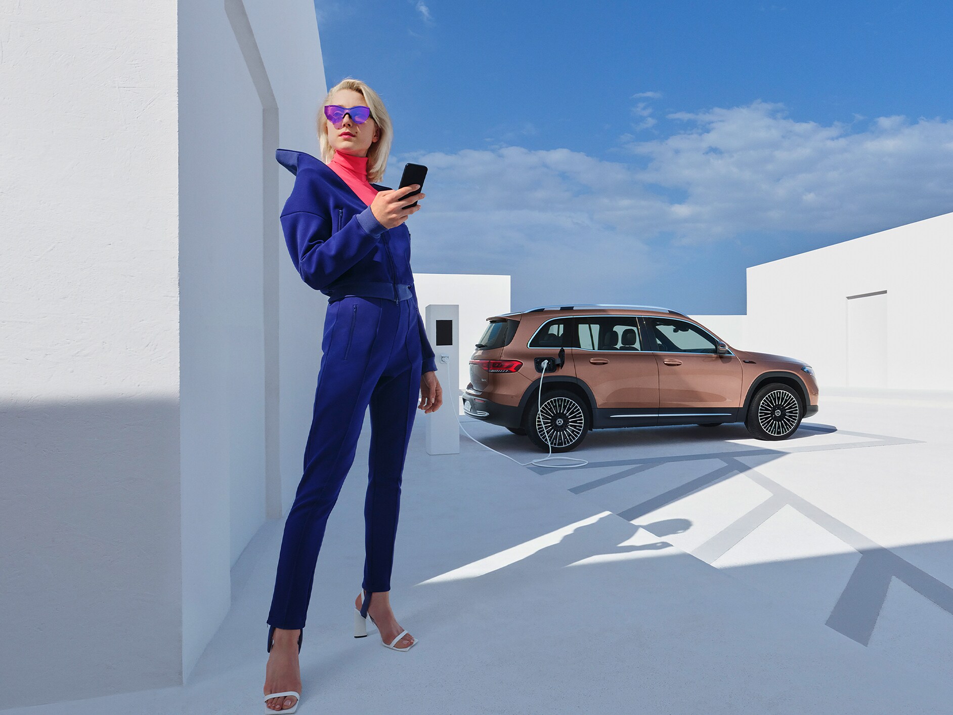 Une femme recharge sa Mercedes-Benz confortablement sur une borne de recharge IONITY.