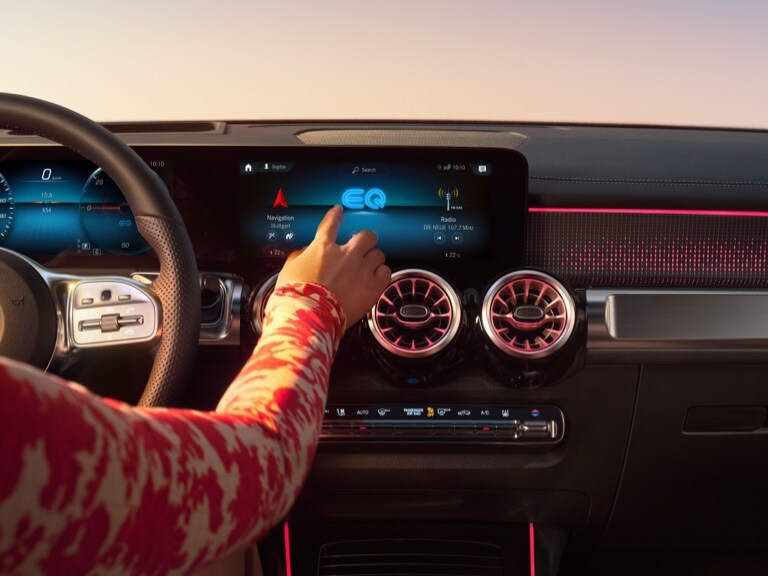 Eine Frau startet die Navigation auf dem MBUX Multimediasystem von Mercedes-Benz.
