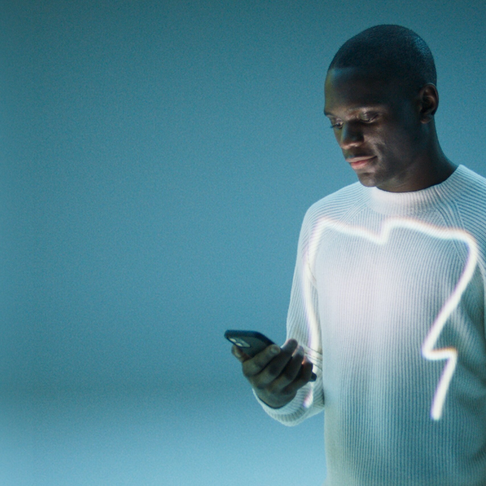Un homme ouvre l’application Mercedes me sur son smartphone.