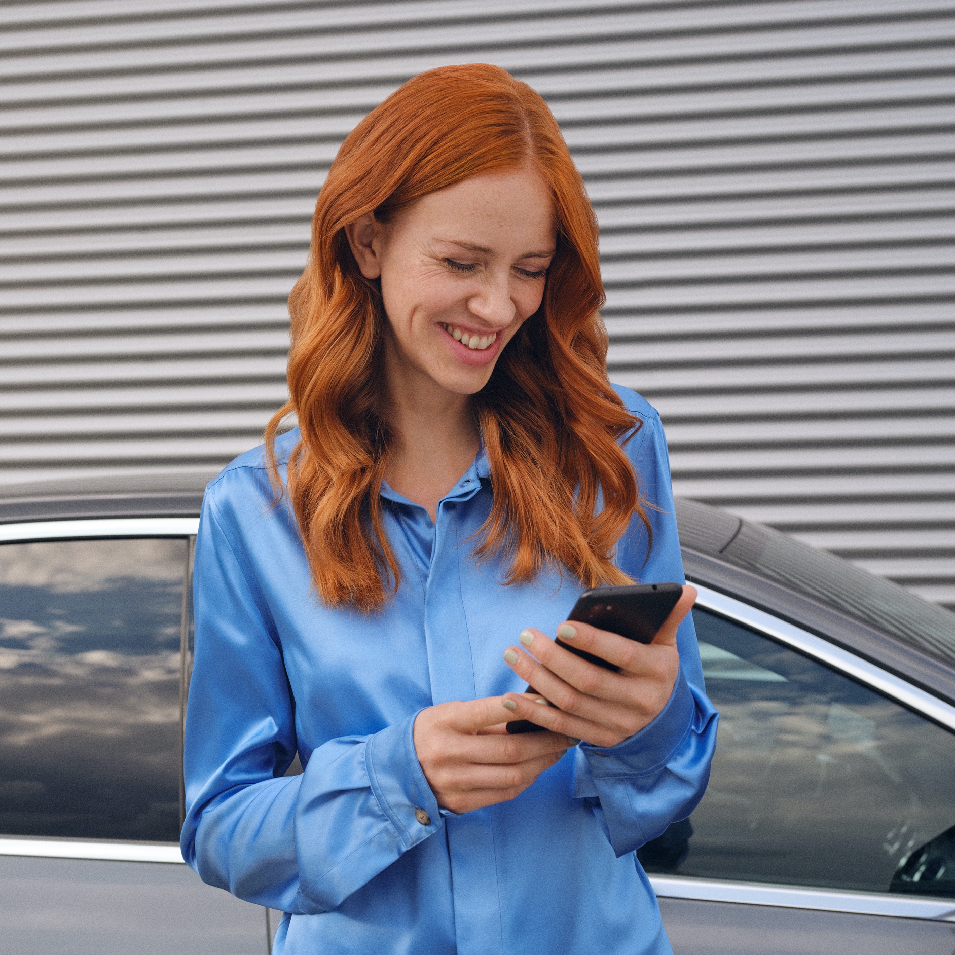 Une femme se connecte à sa Mercedes-Benz via l’application Mercedes me sur son smartphone. Une femme se connecte à sa Mercedes-Benz via l’application Mercedes me sur son smartphone.