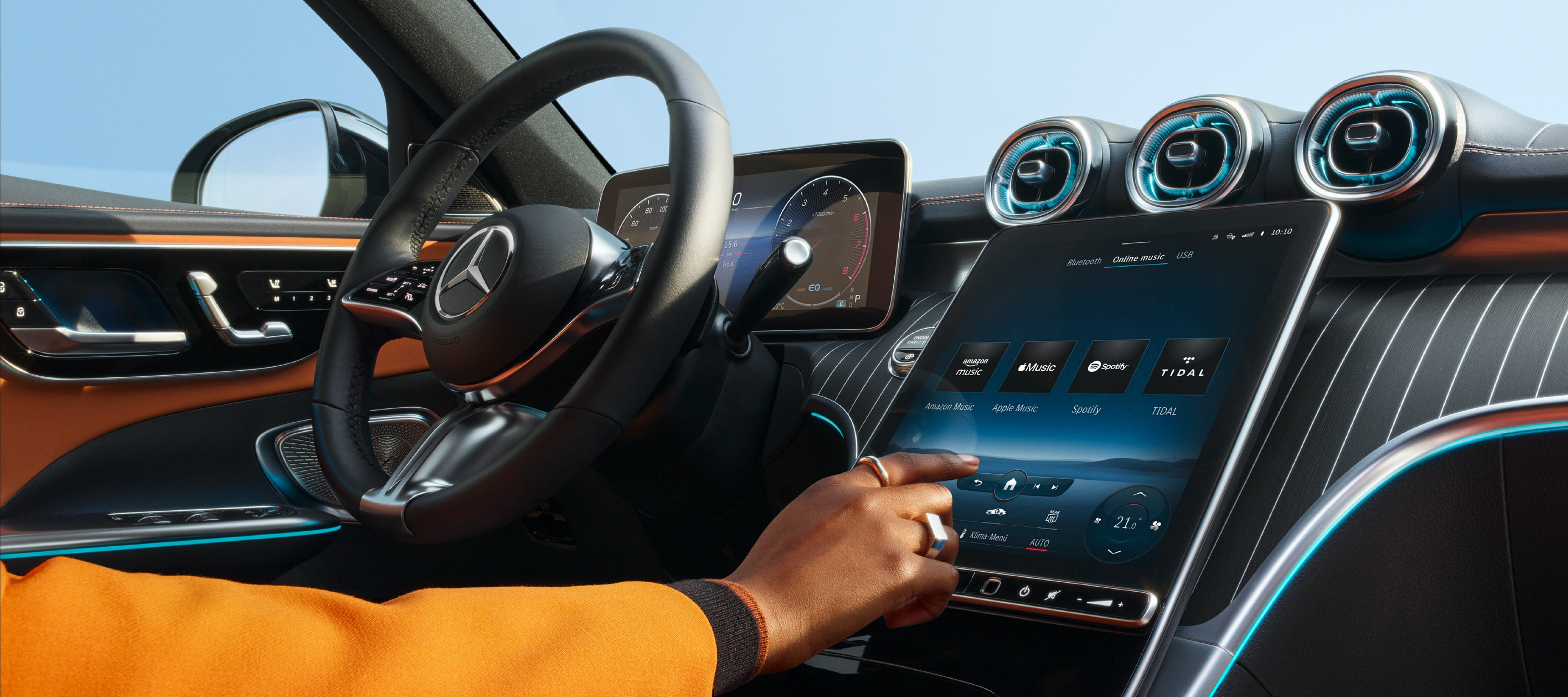 Divertissement | Mercedes-Benz Personne sélectionnant un service de streaming audio sur l'écran du système multimédia MBUX dans une Mercedes-Benz.