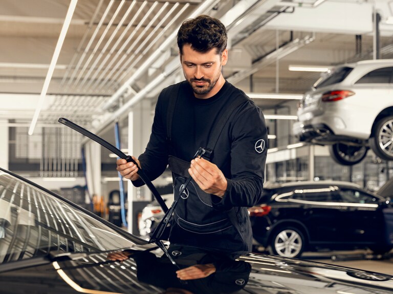 Un technicien Mercedes-Benz procède au remplacement des essuie-glaces.