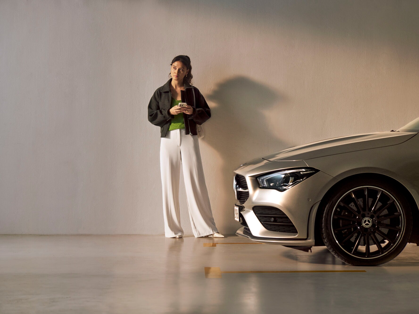 Une femme se tient devant un véhicule Mercedes-Benz.
