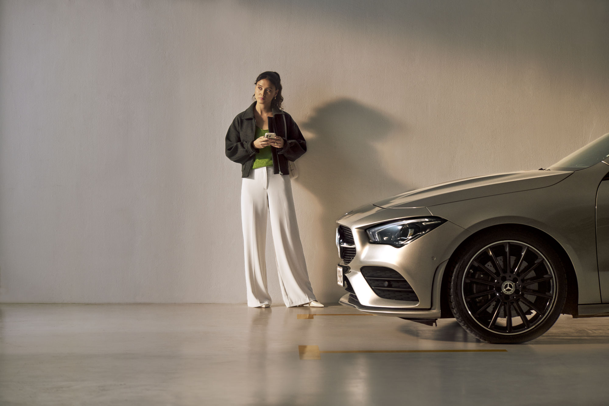 Service Select | Mercedes-Benz Une femme se tient devant un véhicule Mercedes-Benz.