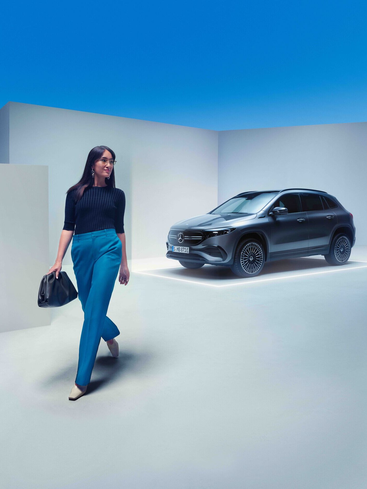 Une femme marche à côté de sa Mercedes-Benz.