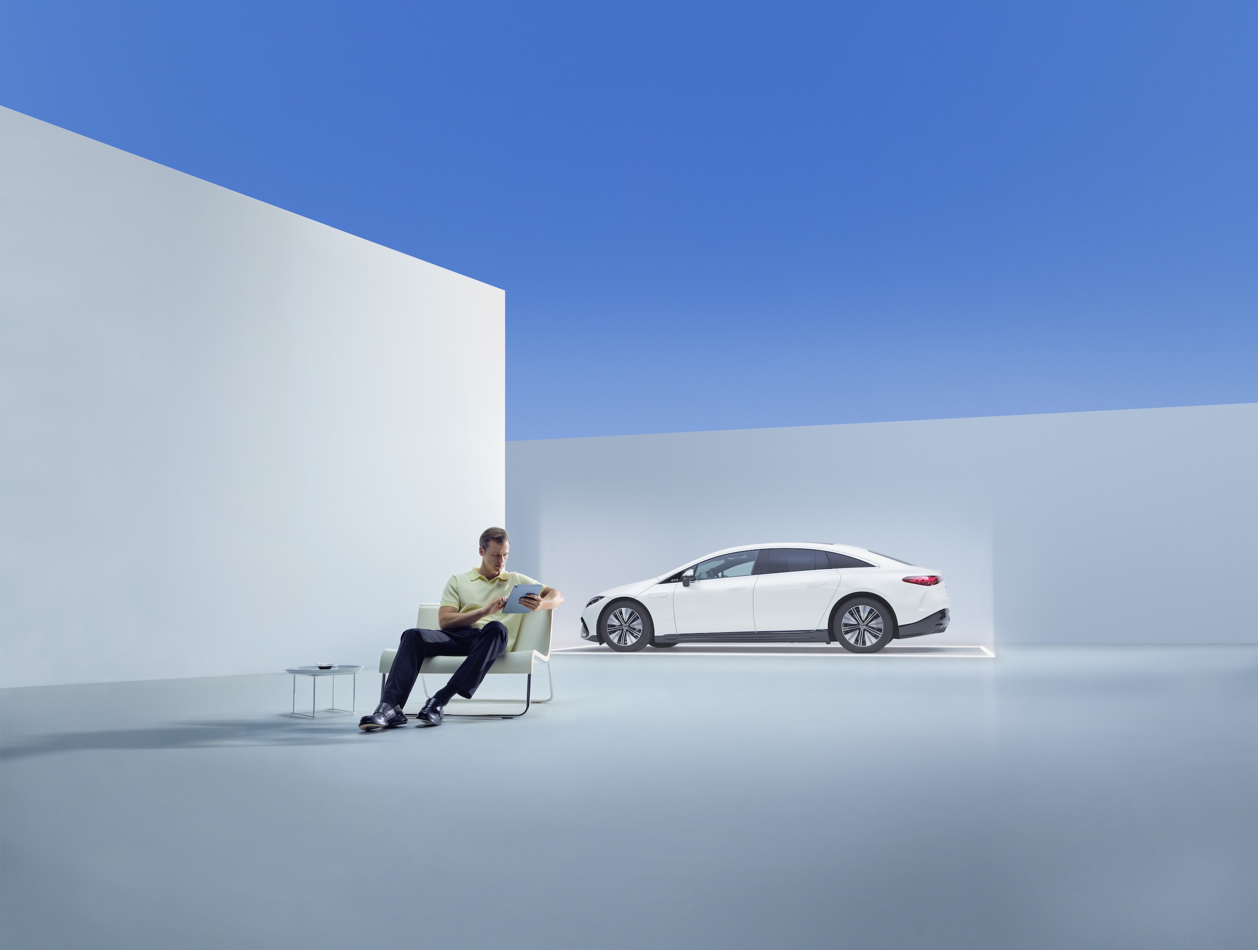 Mercedes-Benz WarrantyExtension Ein Mann entspannt in einem Sessel vor einem Mercedes-Benz.