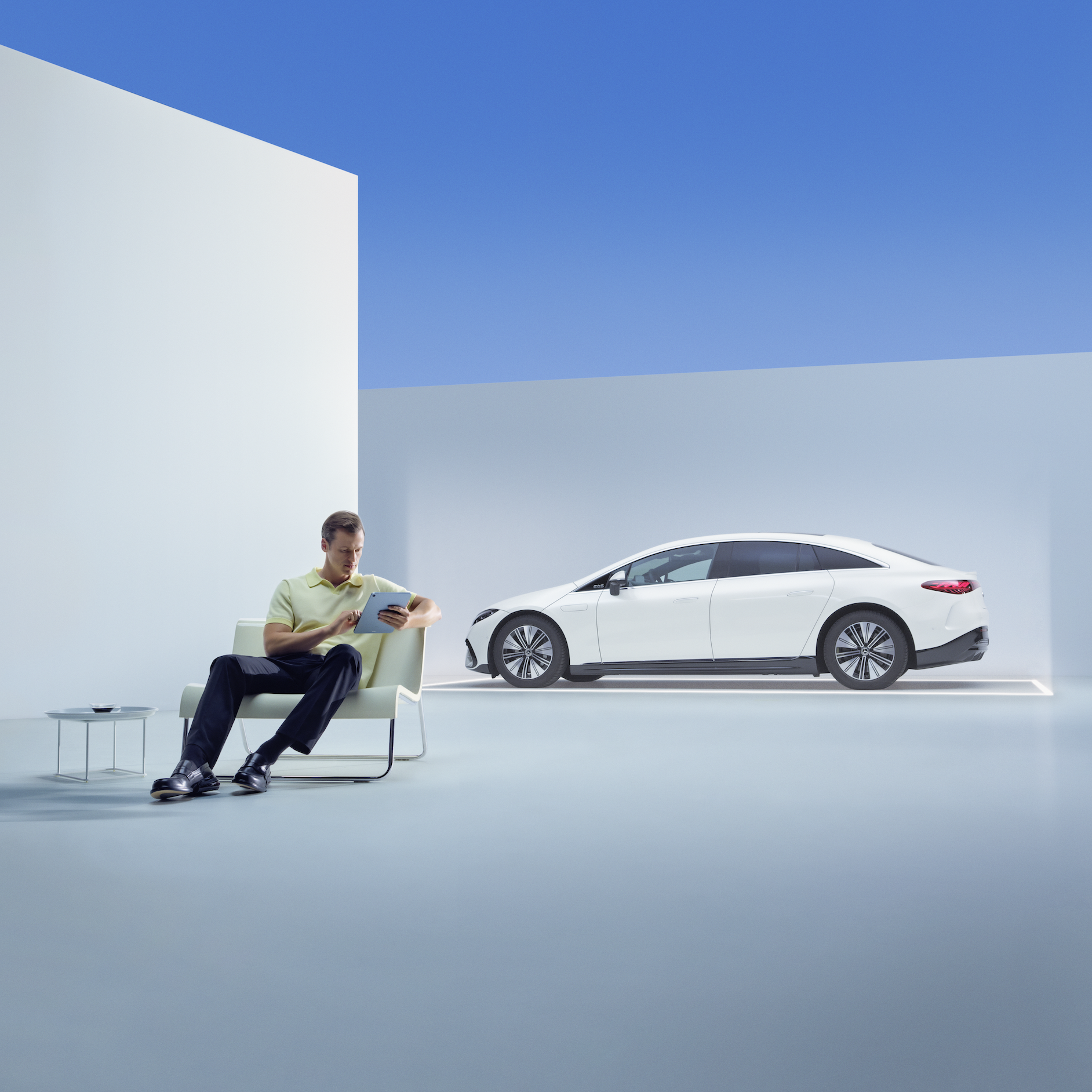 Gute Fahrt mit der Mercedes-Benz Neufahrzeug-Garantie. | Mercedes-Benz Eine entspannter Mann sitzt mit seinem Tablet vor seinem Mercedes.