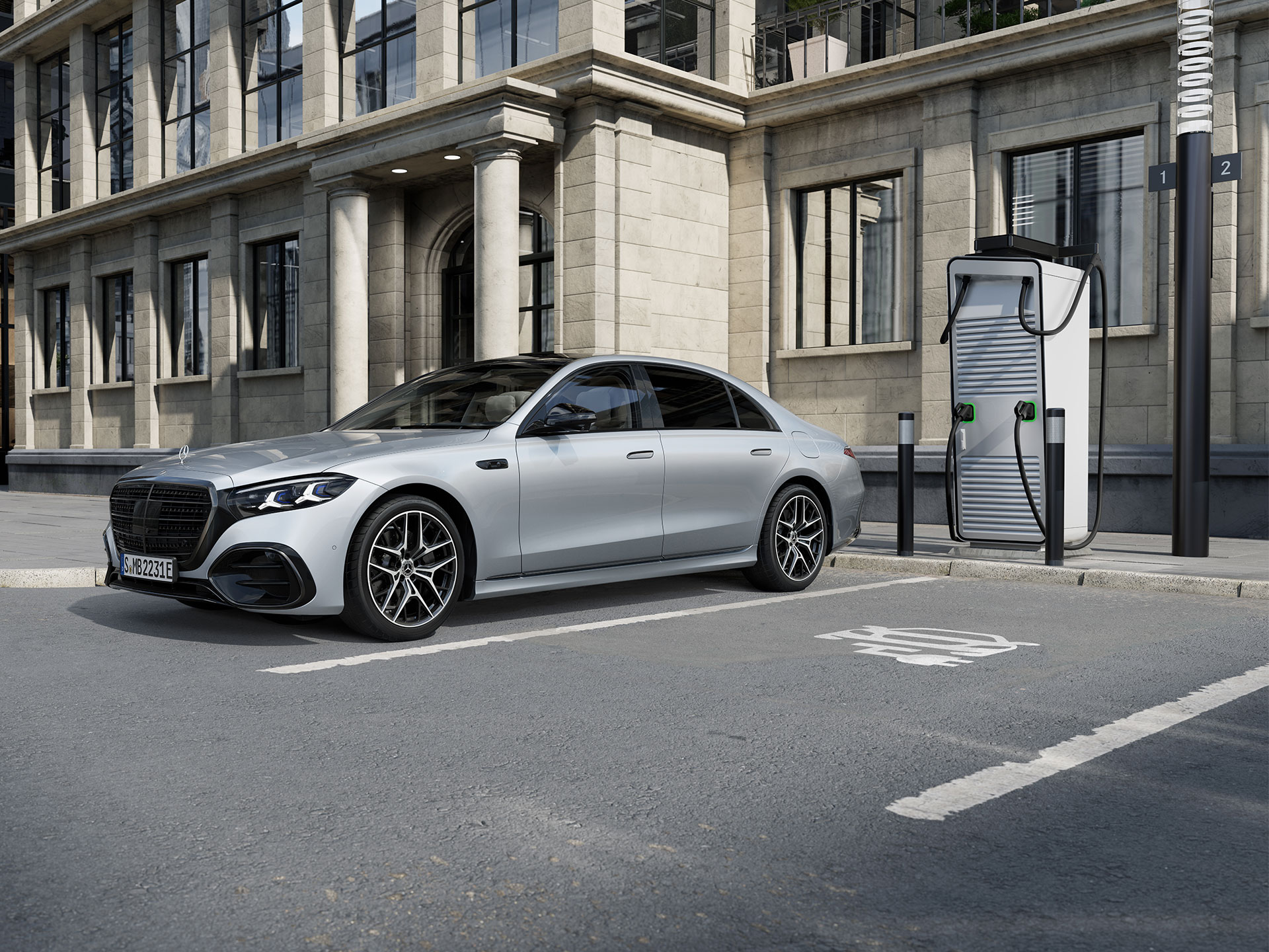 Anreize | Plug-in-Hybride | Mercedes-Benz Der Mercedes-Benz S-Klasse Limousine Plug-in-Hybrid mit langem Radstand in einer 7/8-Seitenansicht, der auf einem Parkplatz neben einer Ladestation steht.