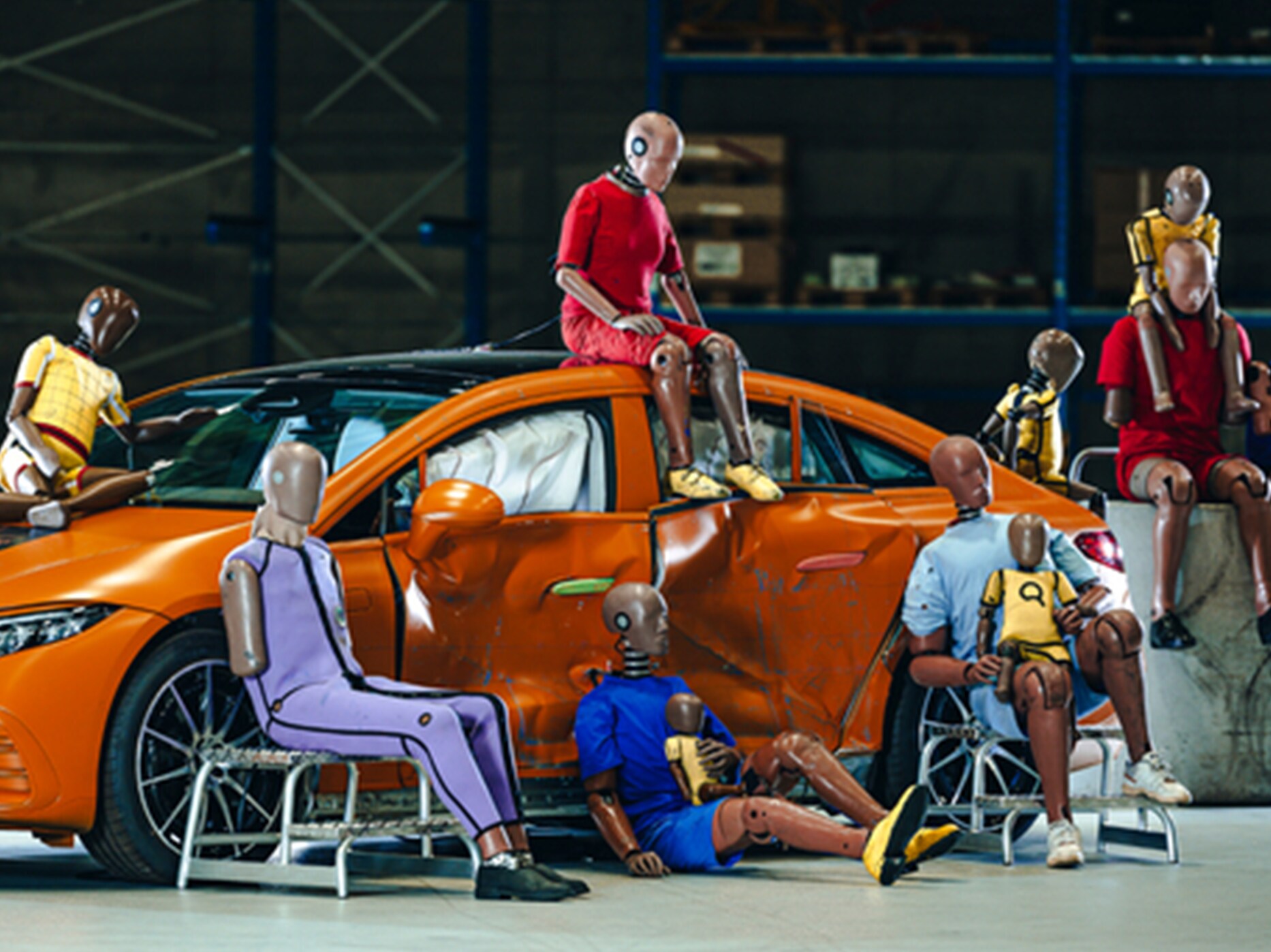 Plusieurs mannequins d’essai de collision assis sur et autour d'une voiture Mercedes-Benz.