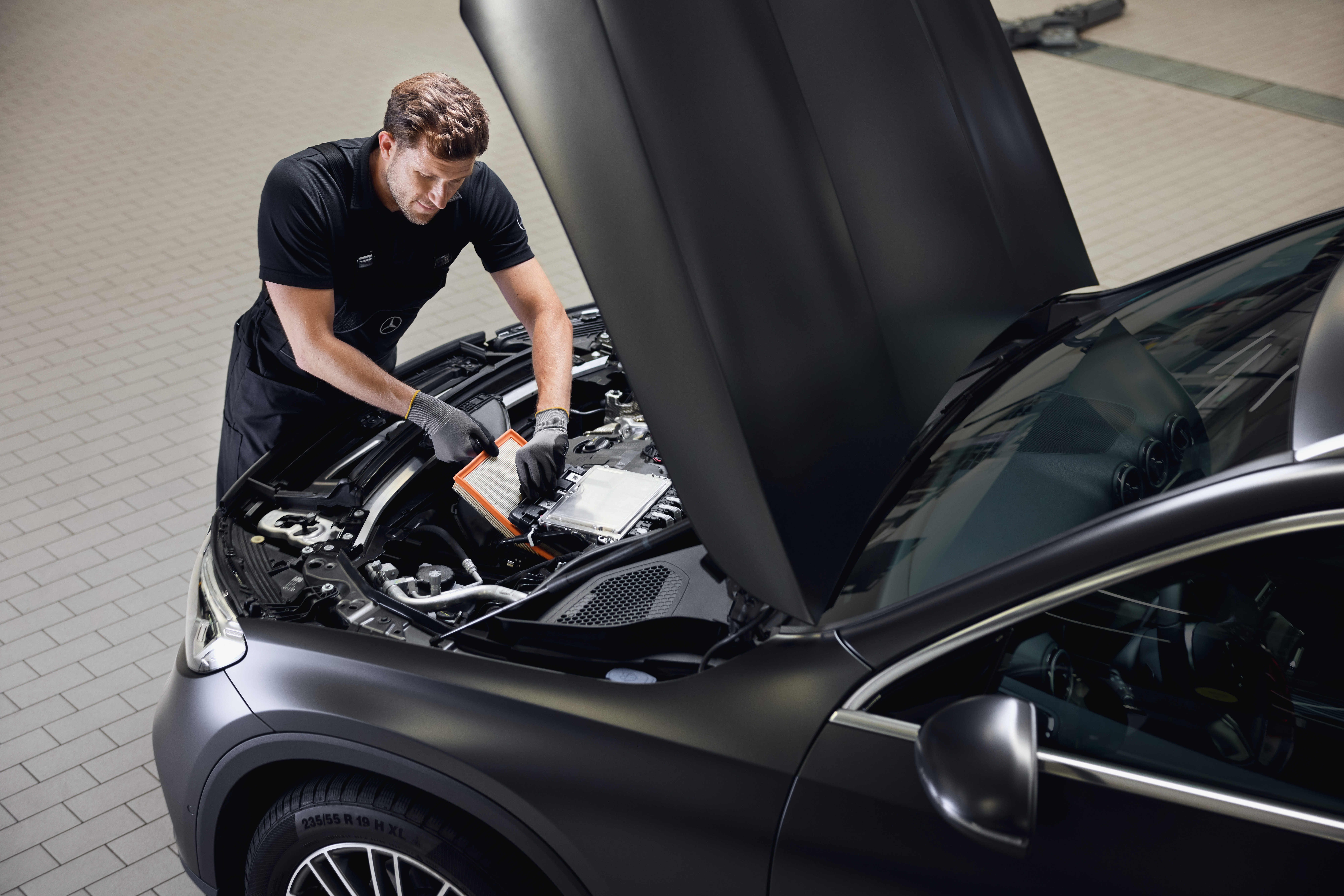 Original-Motorluftfilter von Mercedes-Benz Motorservice zeigt den Austausch eines Motorluftfilters unter Verwendung eines Originalteils von Mercedes-Benz in einer autorisierten Werkstatt.