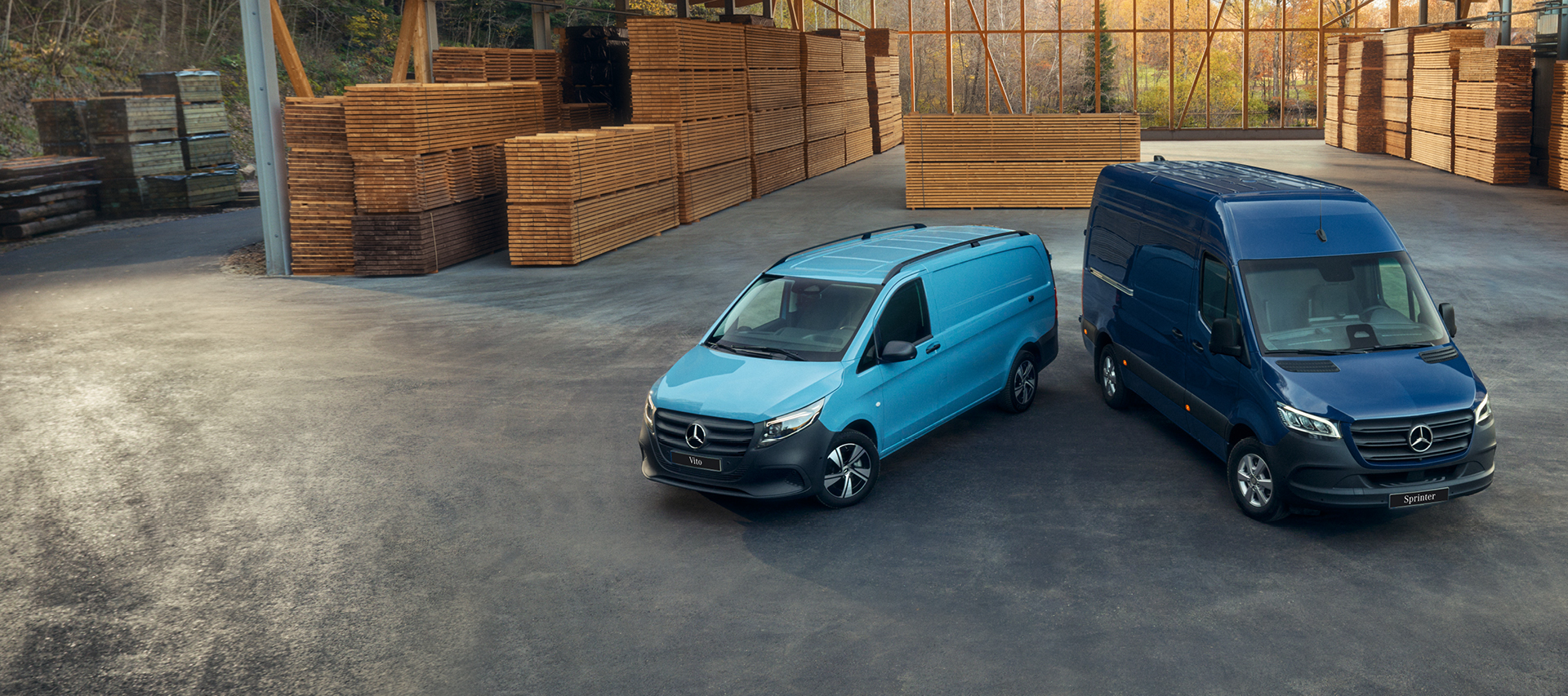 Fourgons Mercedes-Benz dans un entrepôt Deux fourgons Mercedes-Benz bleus dans un entrepôt en bois.
