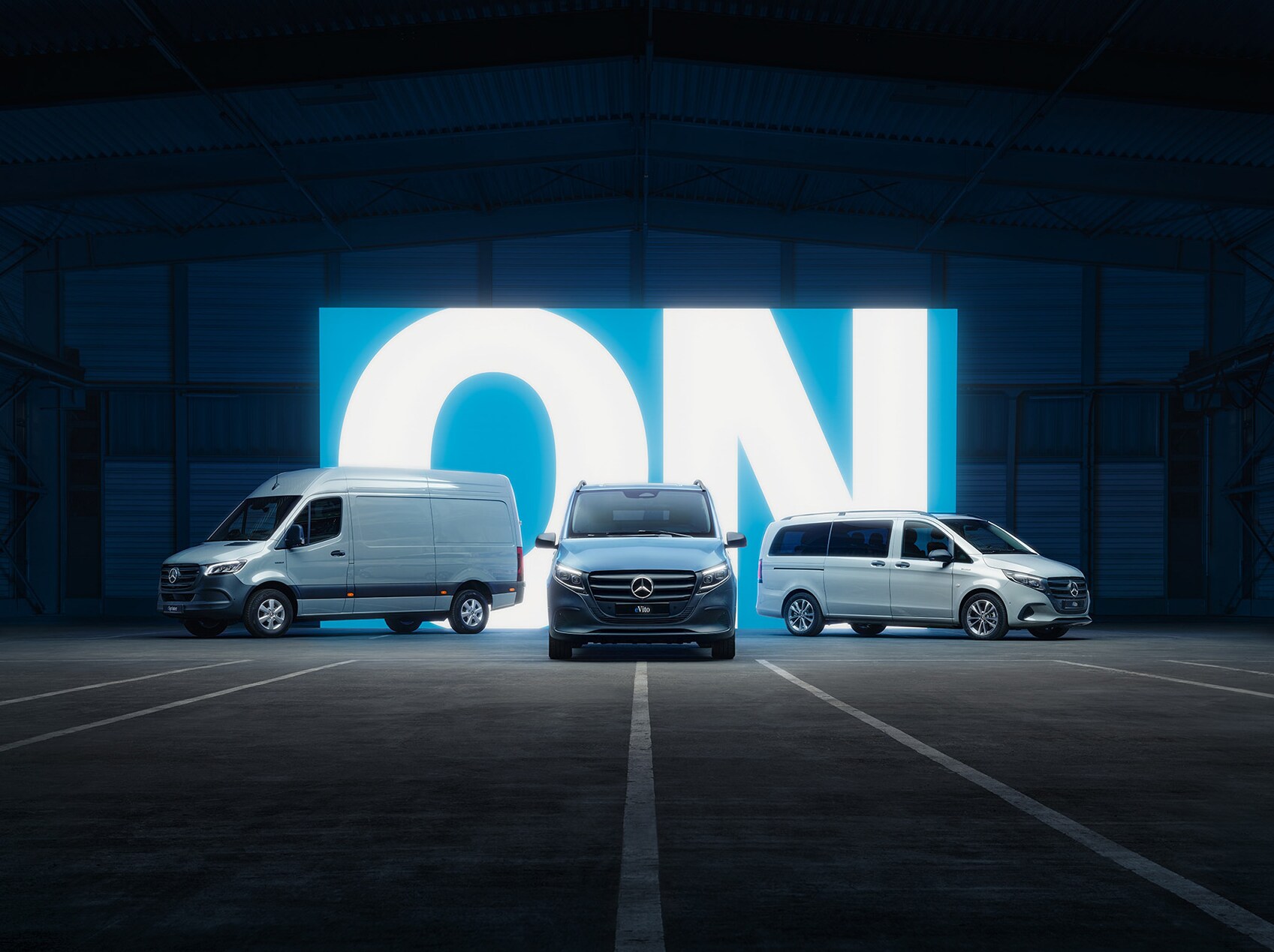 Die Palette der Mercedes‑Benz-Elektrotransporter mit eSprinter und eVito in einem beleuchteten Showroom.