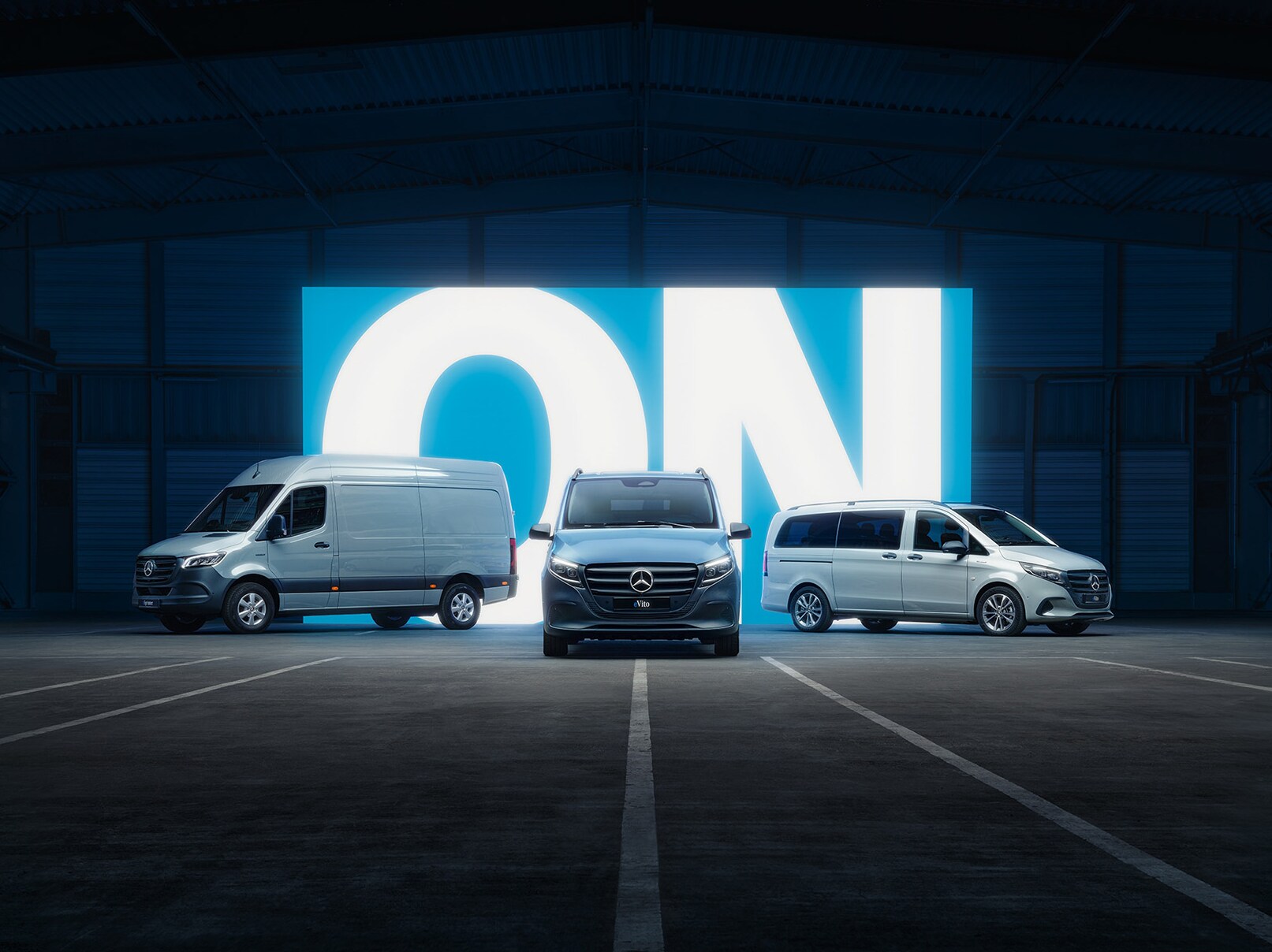 La gamme de fourgons électriques Mercedes-Benz, avec l'eSprinter et l'eVito, exposée dans un show-room éclairé.
