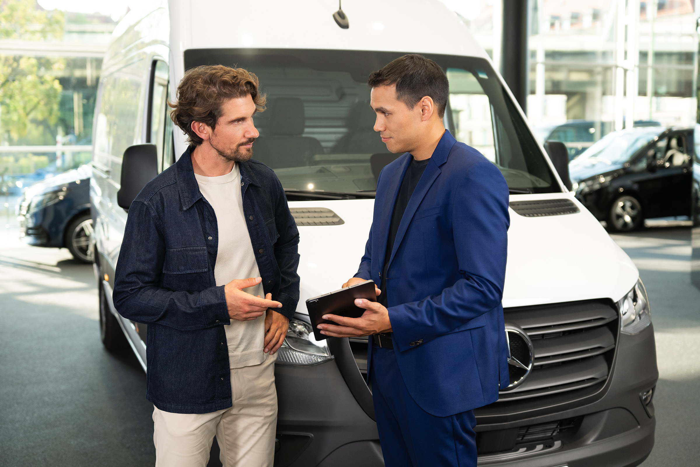Finanzierungsleasing | Elektromodelle | Mercedes-Benz Beratung zu Mercedes-Benz Transportern in einem Showroom, bei der der kundenorientierte Service im Vordergrund steht.