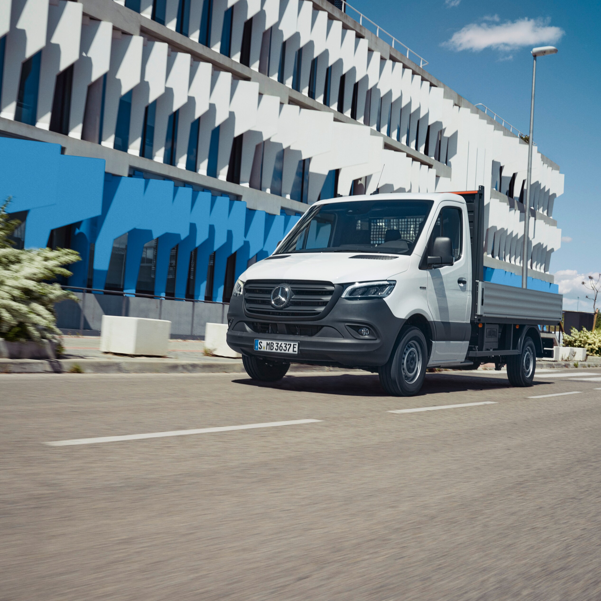 Le Mercedes-Benz eSprinter à plateau en déplacement en ville.