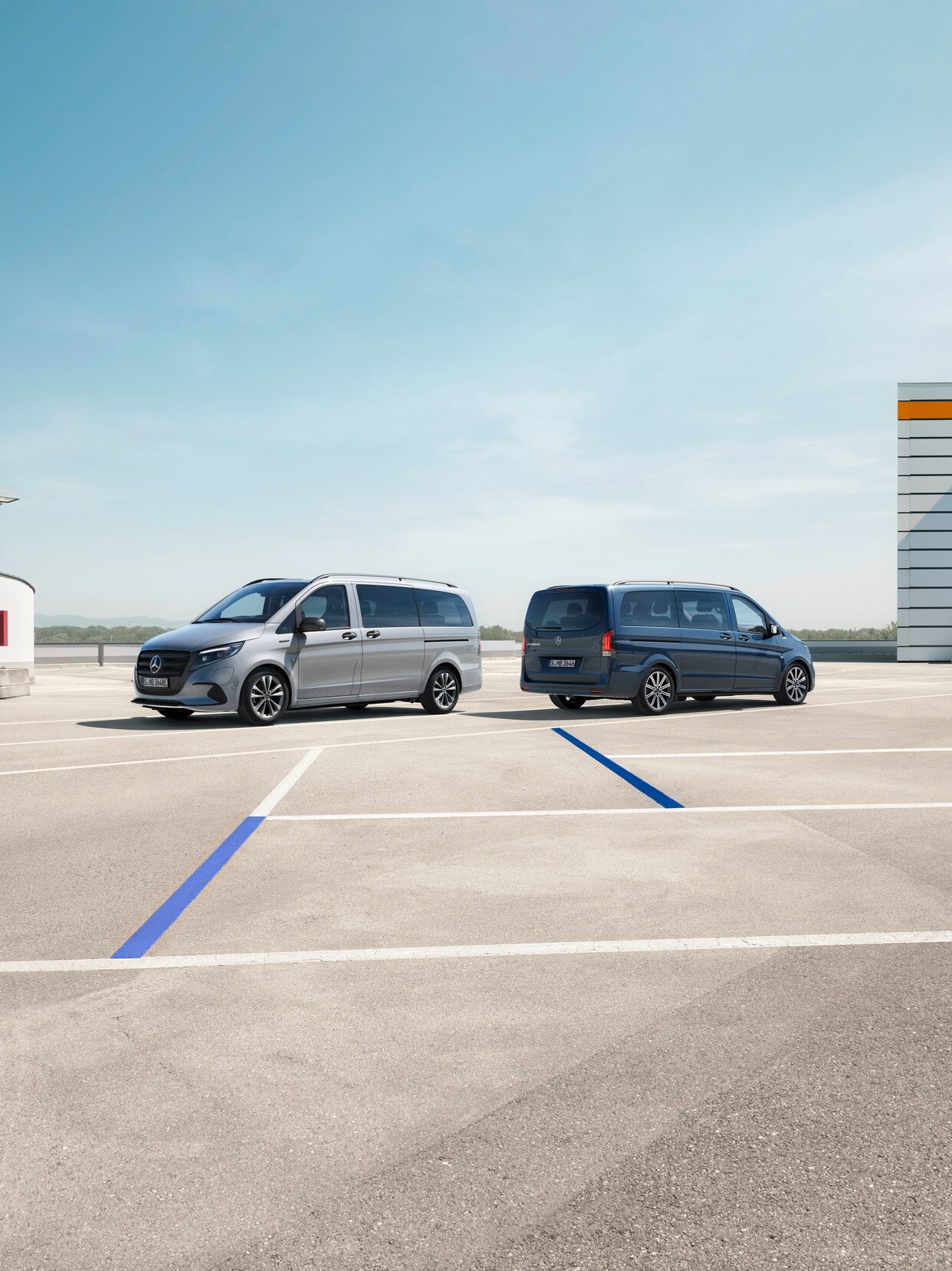 Der eVito Tourer und Vito Tourer stehen auf einem Parkplatz.