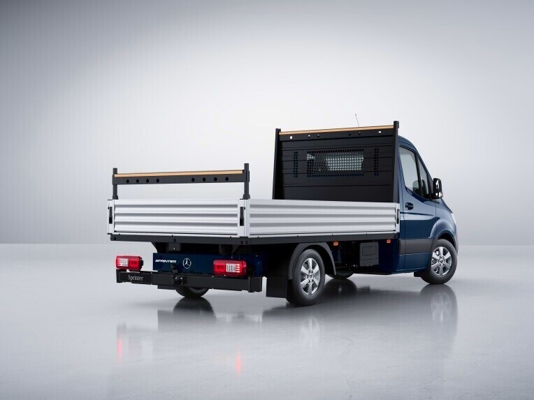Le Mercedes-Benz Sprinter à plateau avec porte-échelle.