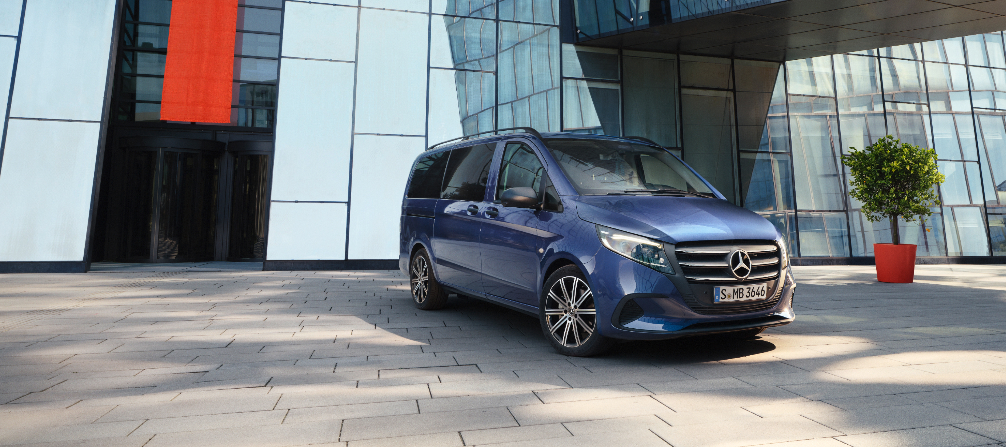 Comparaison des véhicules | Vito Tourer | Mercedes-Benz La Mercedes-Benz Vito Tourer devant un immeuble de bureaux.