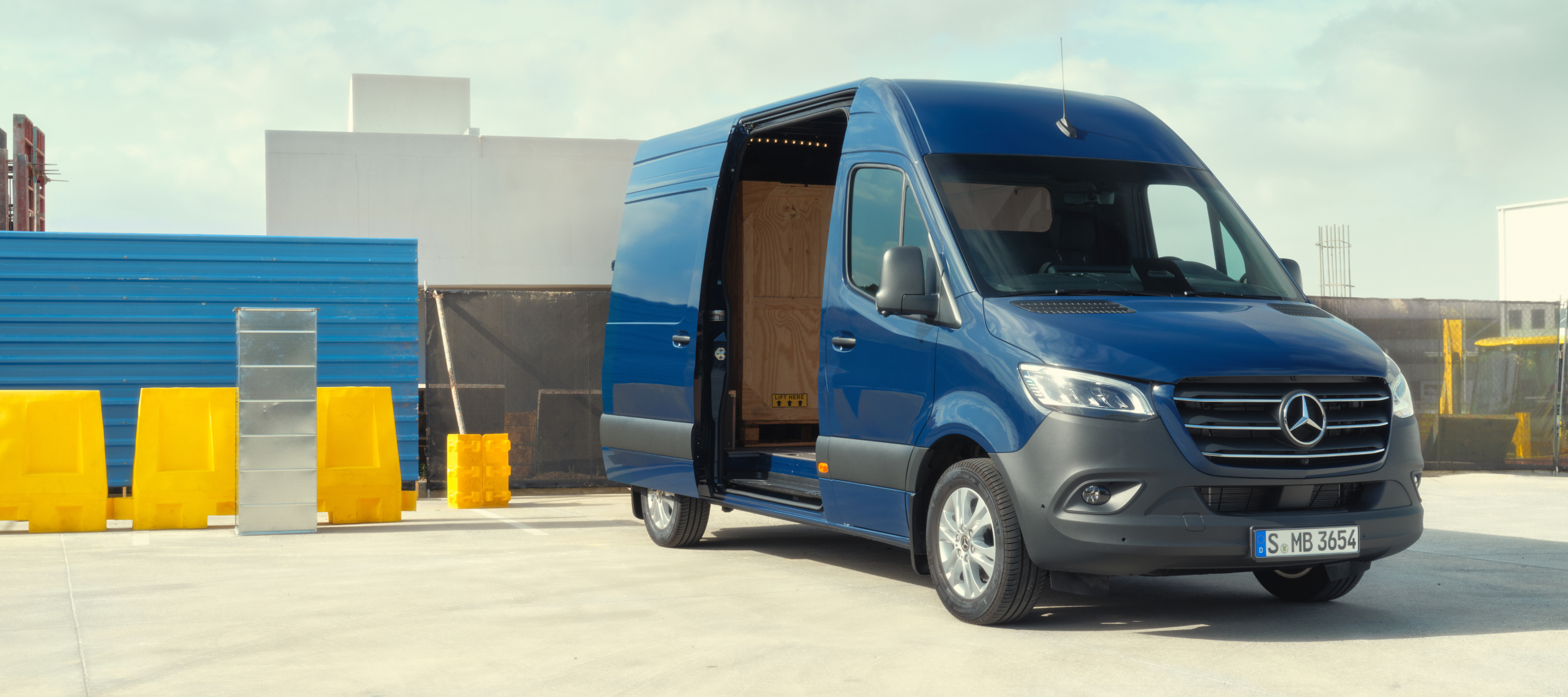 Comparaison de véhicules | Sprinter fourgon | Mercedes-Benz La Mercedes-Benz Sprinter fourgon devant des matériaux de construction.