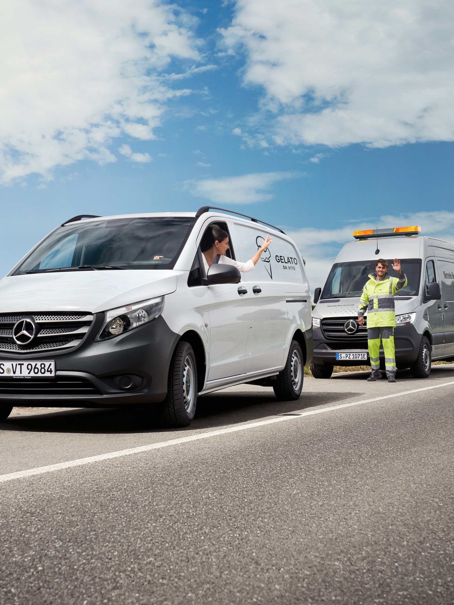 Une personne à bord d’un utilitaire léger Mercedes-Benz Vito blanc fait signe à un technicien de maintenance garé sur le bord de la route.