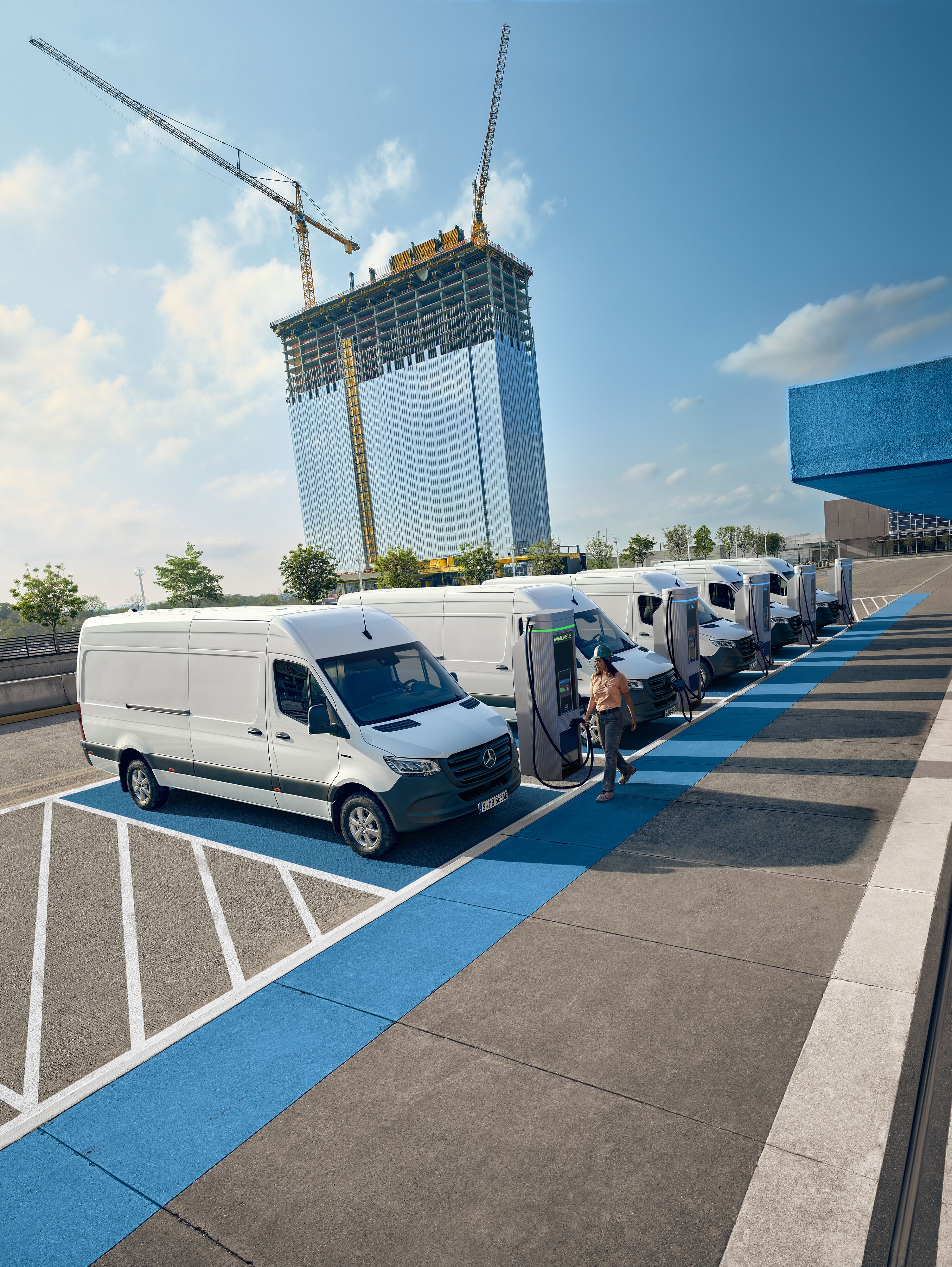 Plusieurs utilitaires légers Mercedes-Benz Sprinter blancs en train de se recharger aux bornes de recharge.