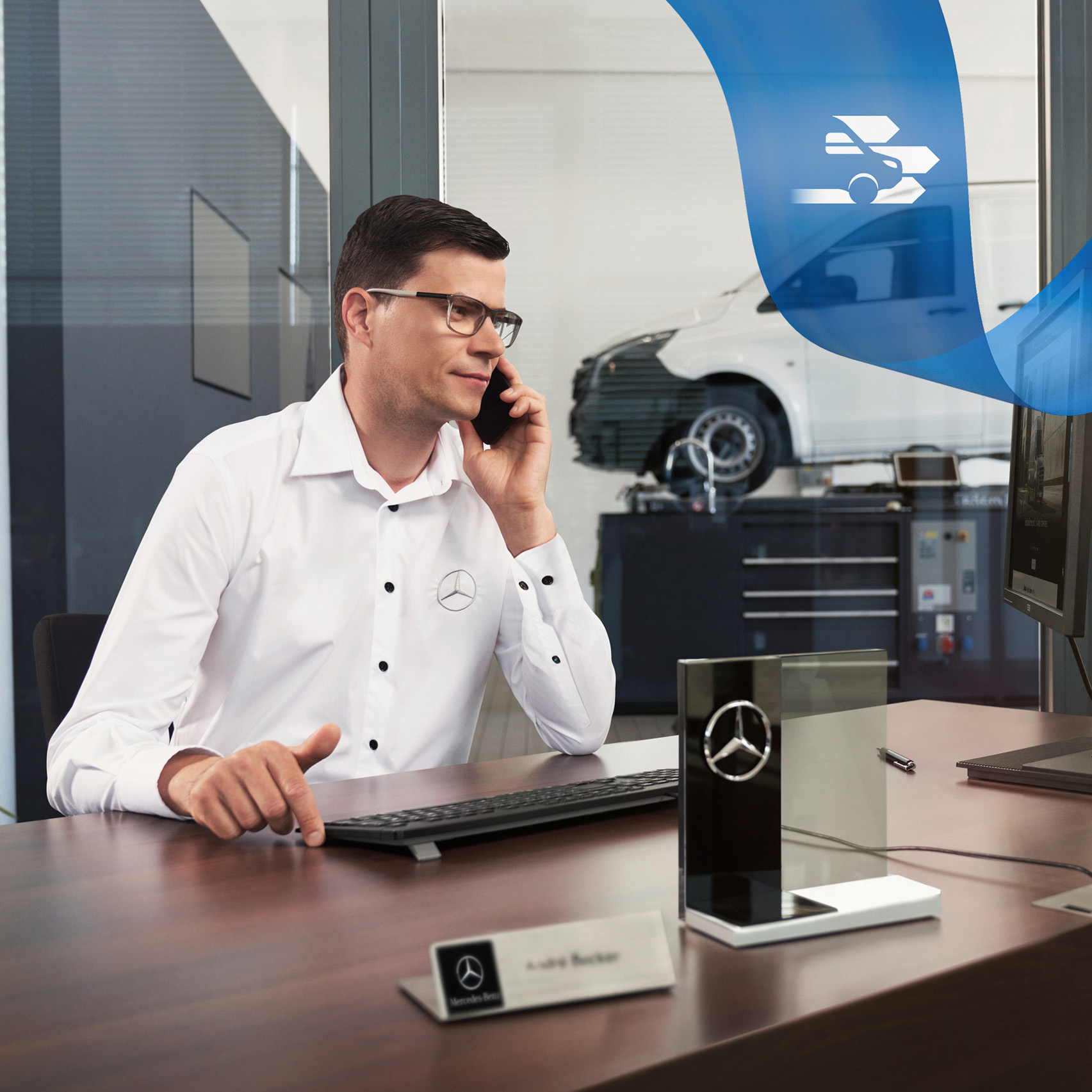 Mercedes-Benz | Maintenance des utilitaires légers | Assistance dépannage Un employé au téléphone et une utilitaire léger Mercedes-Benz Vito dans l'atelier à l'arrière-plan.