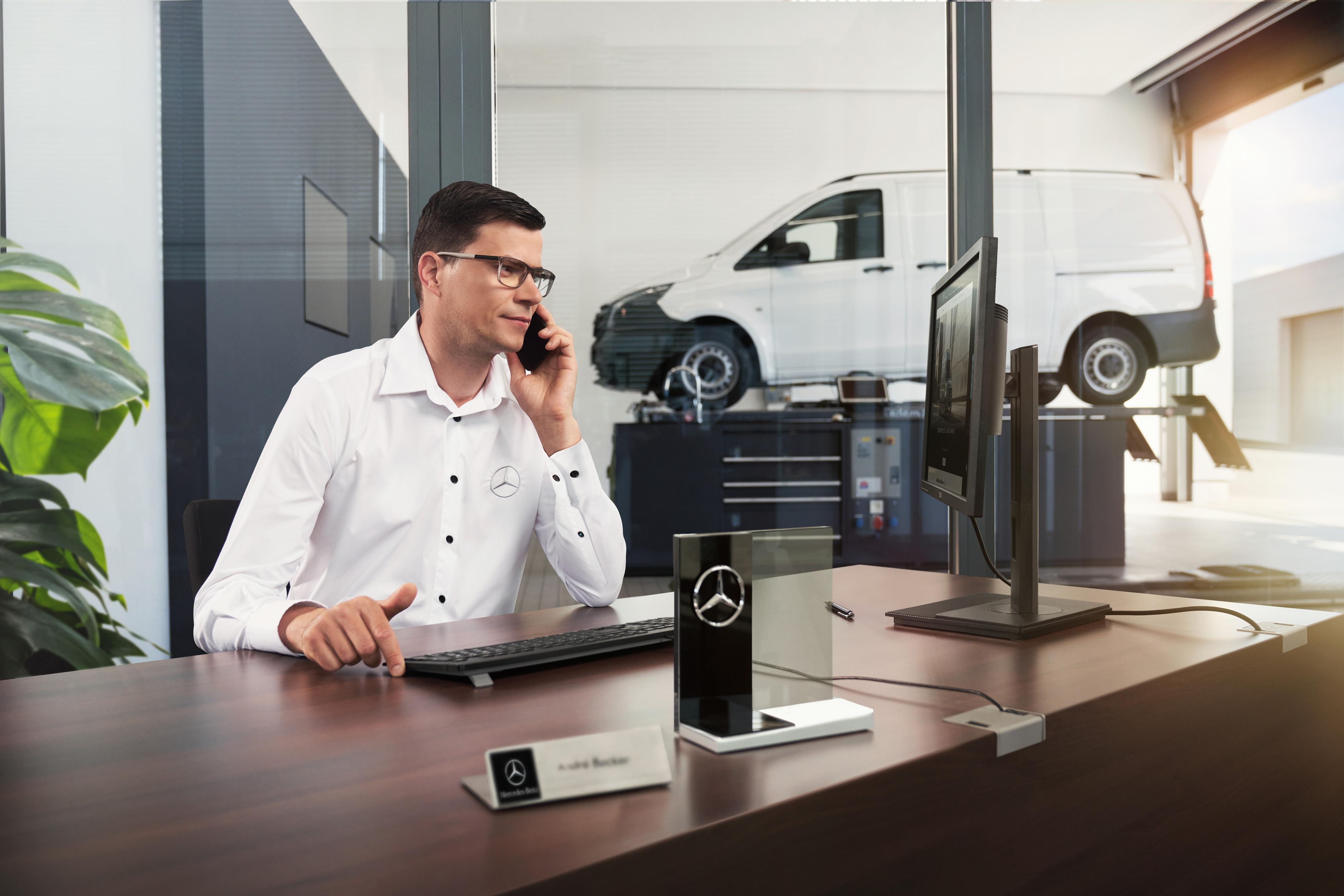 Mercedes-Benz | Komfort | Servicepartner Mercedes-Benz Serviceberater telefoniert in einer Werkstatt.