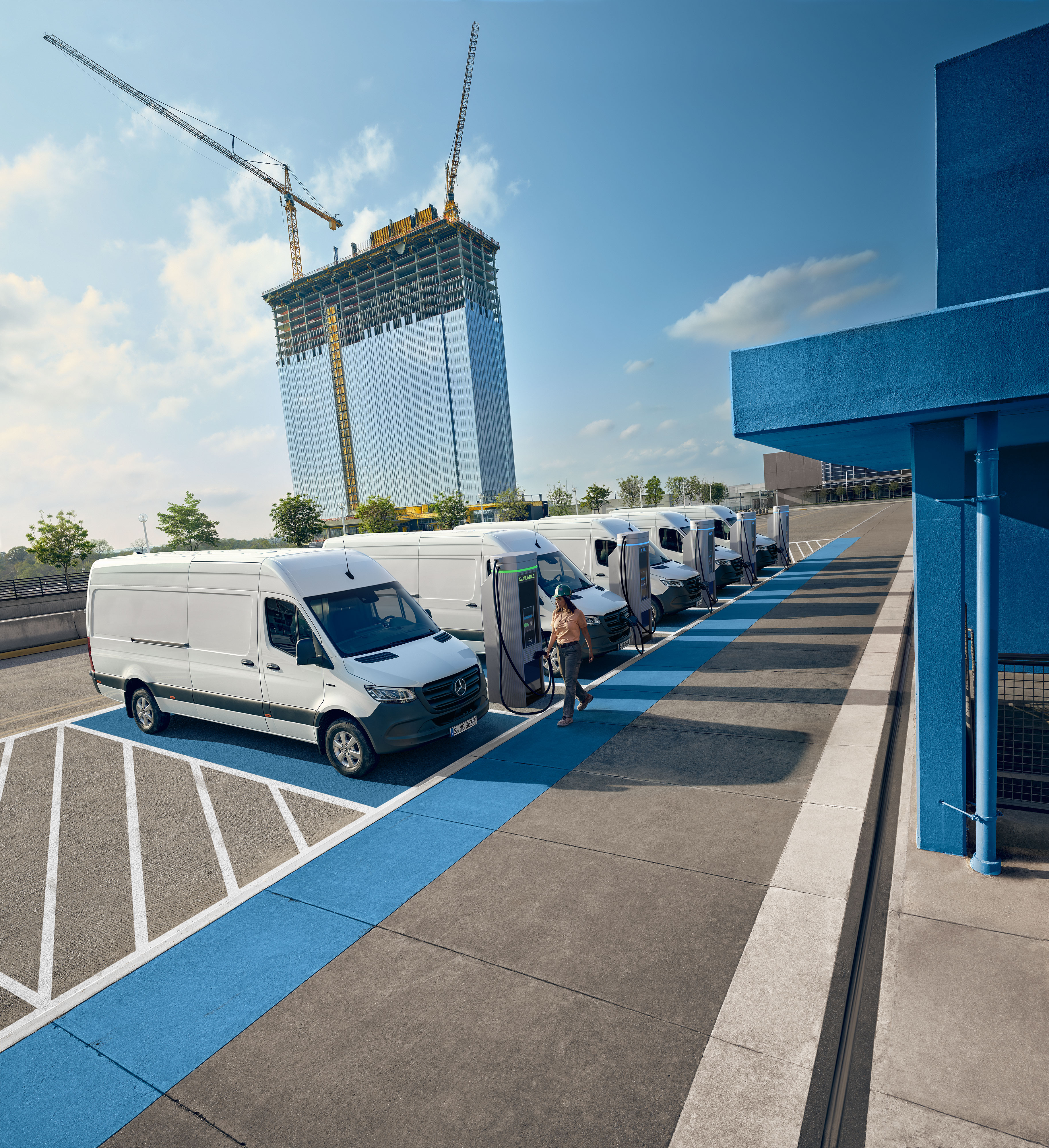 Mercedes-Benz | Confort Une flotte d’utilitaires légers électriques Mercedes-Benz blancs garés à une borne de recharge.