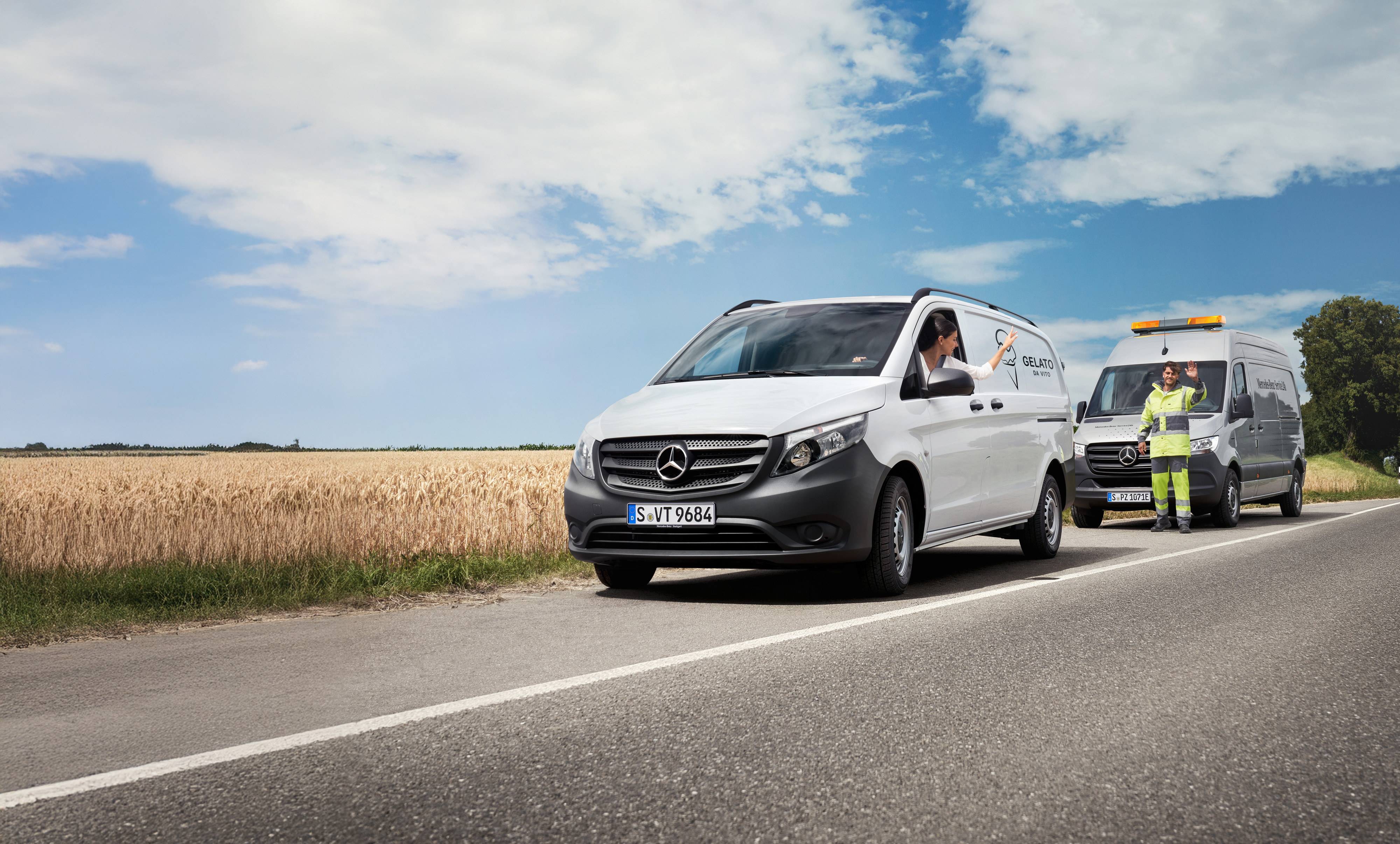 Mercedes-Benz | Komfort | MobiloVan Eine Frau sitzt in einem weißen Mercedes-Benz Vito und winkt einem Mercedes-Benz Servicetechniker am Straßenrand zu.