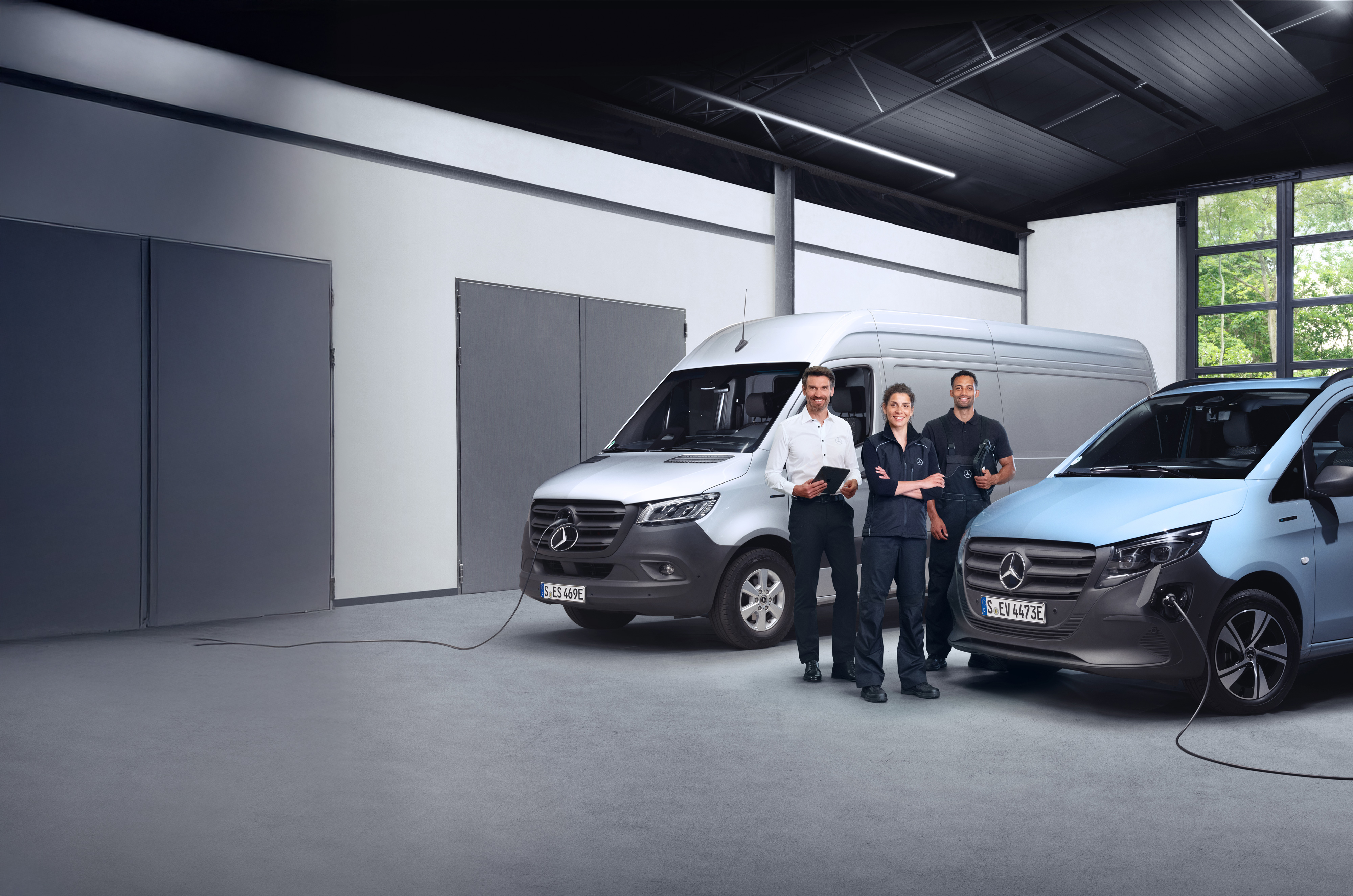 Mercedes-Benz | Vue d’ensemble de la qualité des utilitaires légers Trois employés devant des fourgons Mercedes-Benz, symboles de qualité.