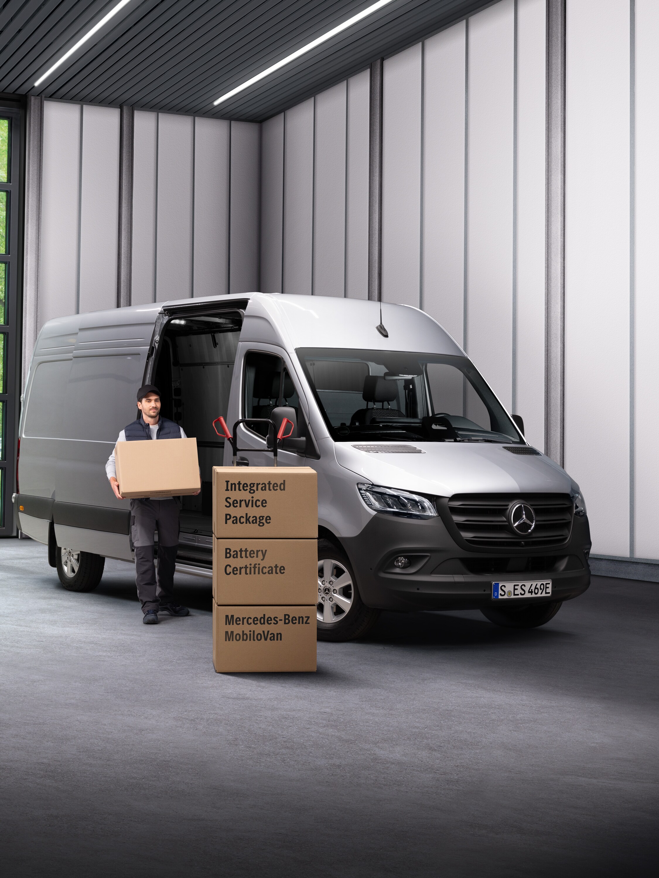 Ein Mercedes-Benz Elektroservice-Mitarbeiter trägt Kisten aus einem Transportfahrzeug