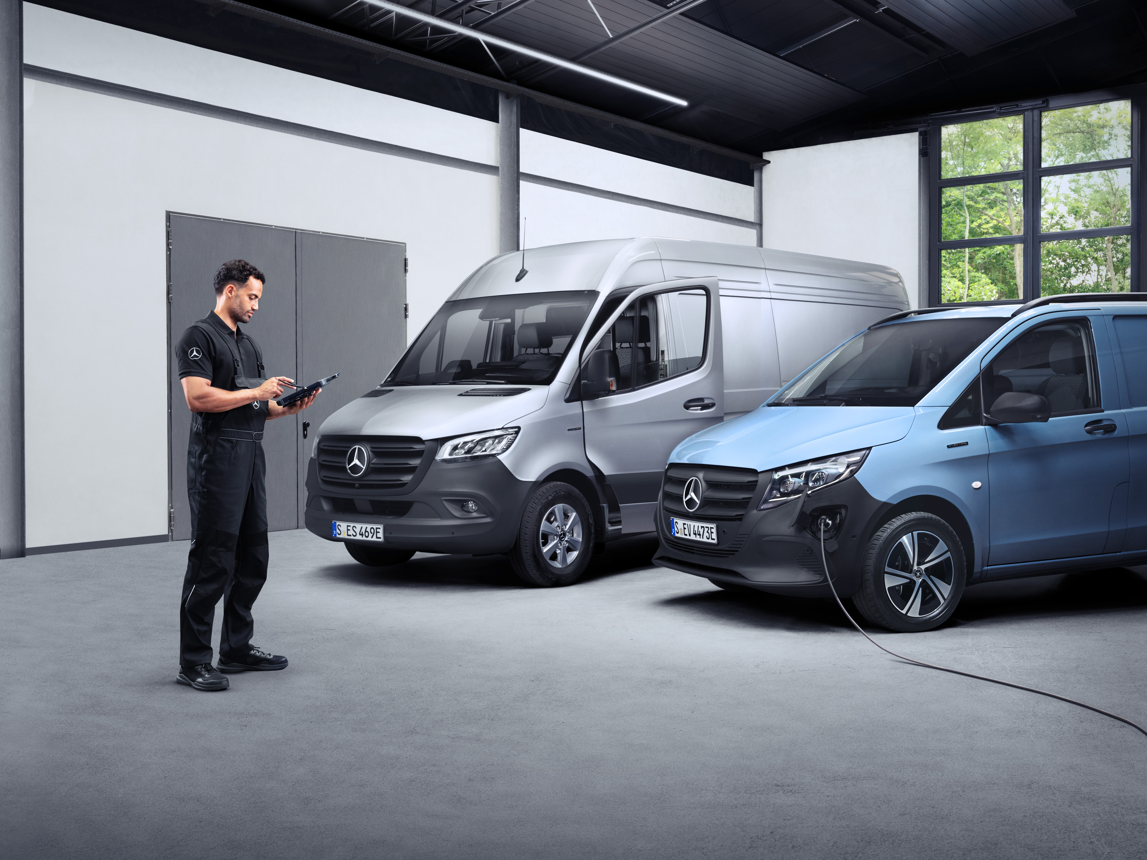 Mercedes-Benz | Maintenance des utilitaires légers Un technicien devant deux eVans sur une tablette