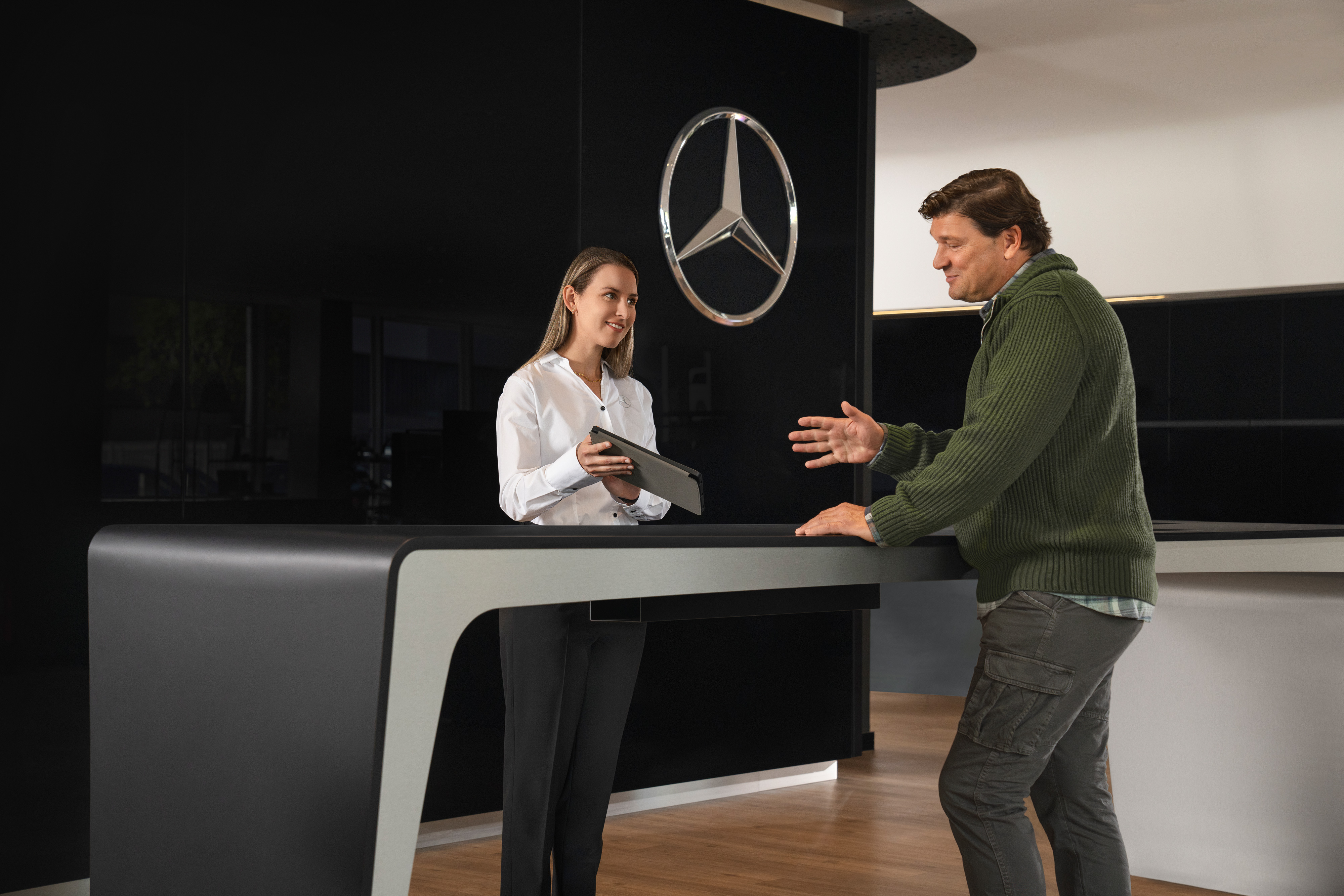 Mercedes-Benz | Service véhicules électriques | Consultation Un conseiller Mercedes-Benz fournit à un client des informations personnalisées.