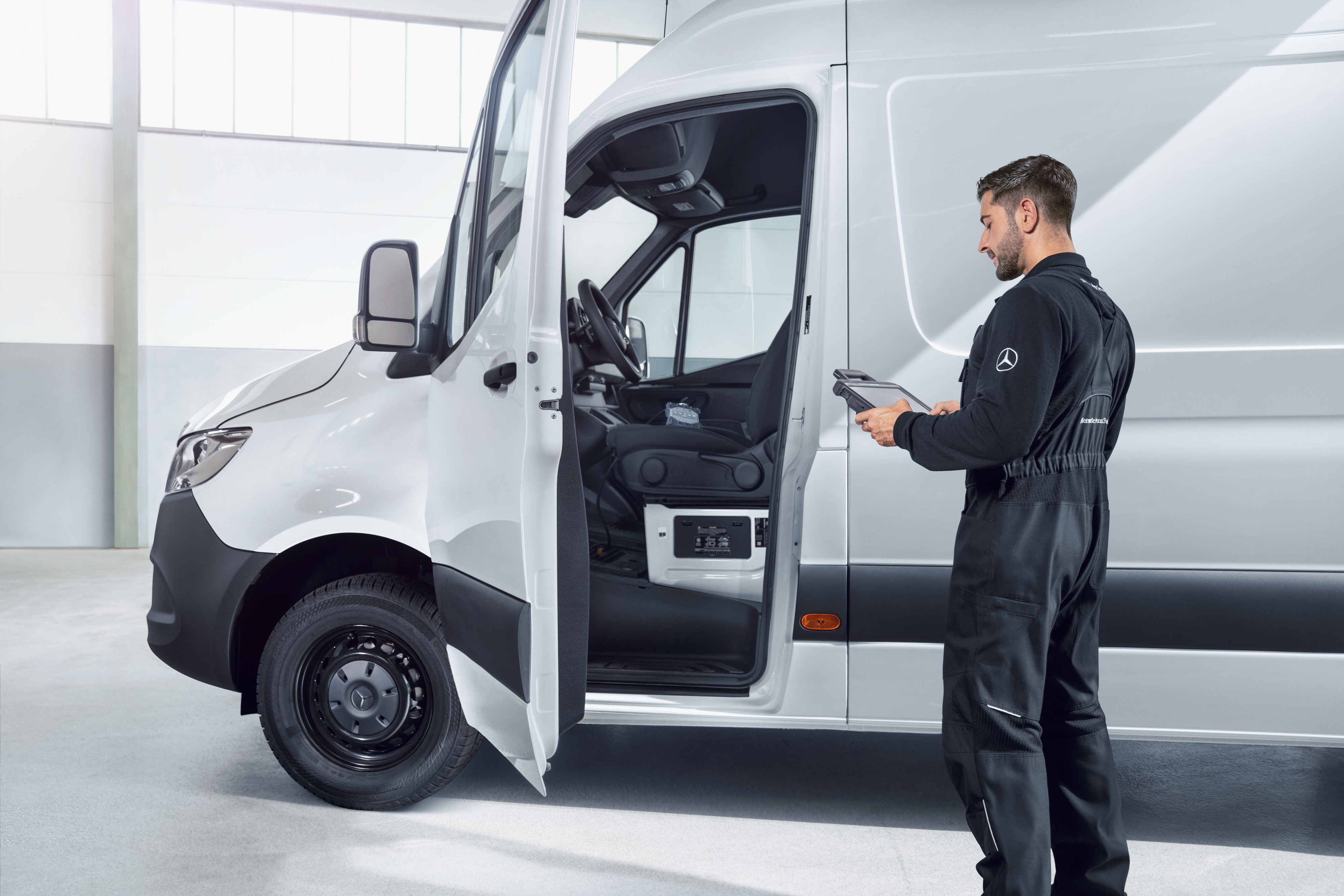 Mercedes-Benz | Serviceübersicht | Fahrzeugwartung Ein Mitarbeiter inspiziert einen Mercedes-Benz Transporter, der zuverlässige Servicequalität bei Wartung und Reparatur bietet.