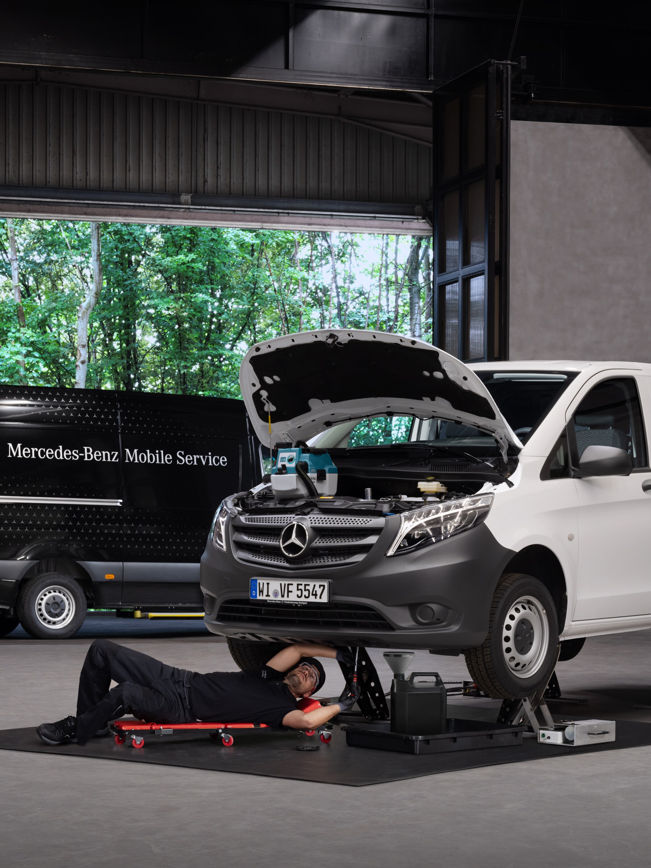 Un technicien répare un utilitaire léger Mercedes-Benz Vito blanc.