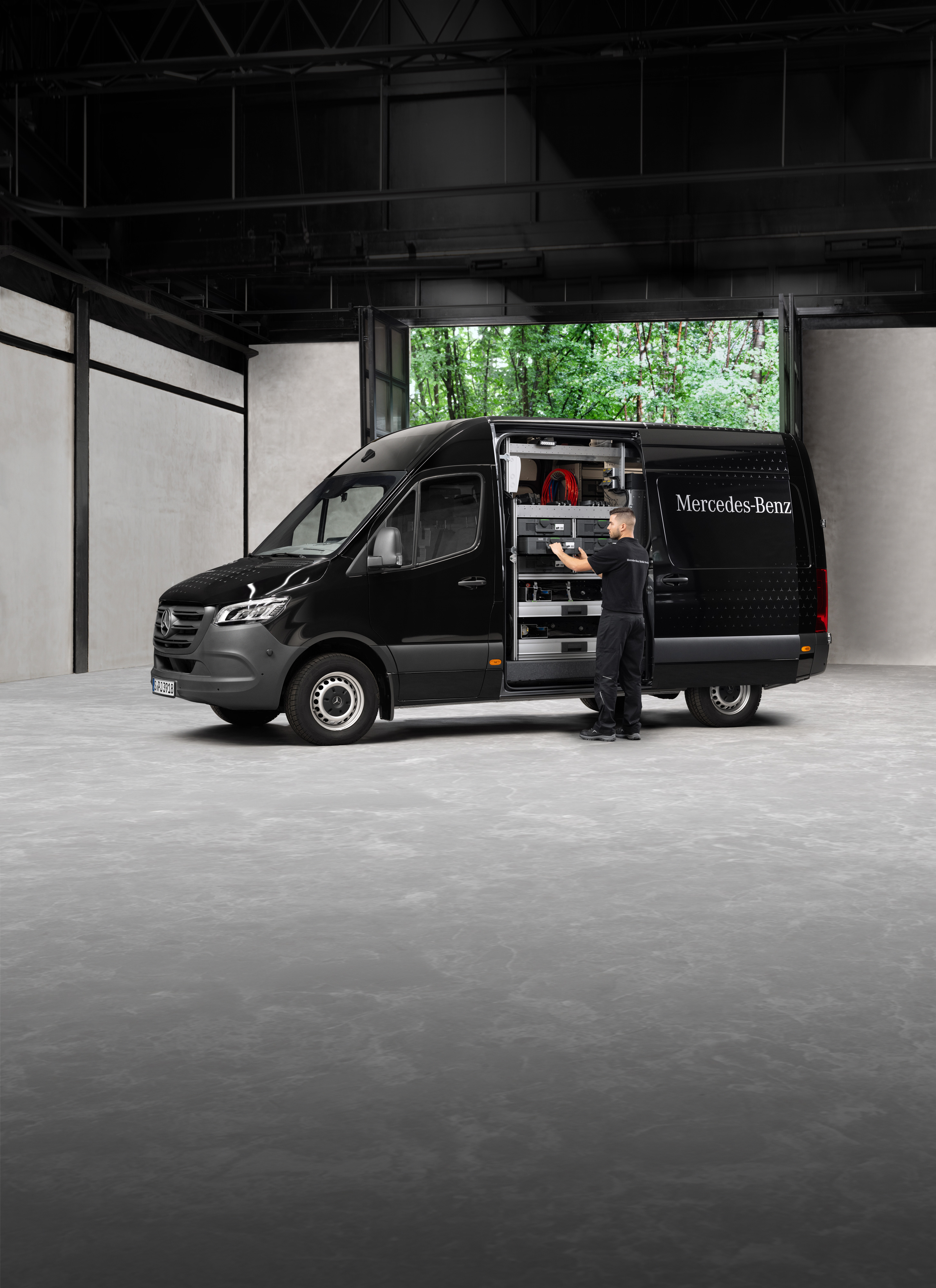 Mercedes-Benz | Mobiler Service | Jahreszeiten-Check Ein Techniker holt Werkzeuge aus einem schwarzen Mercedes-Benz Sprinter.